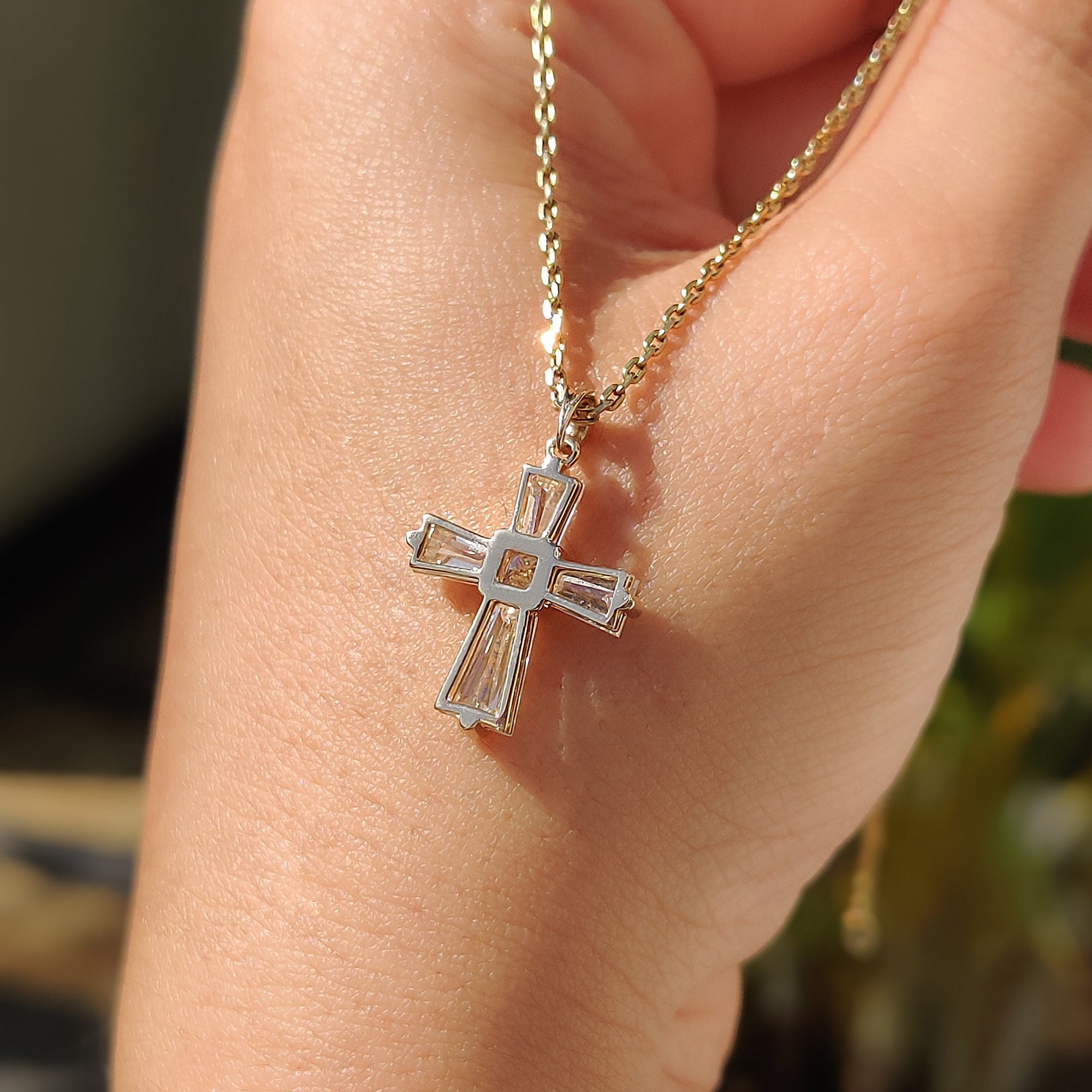Handmade jewelry pendant with gold cross and bright moissanite.
