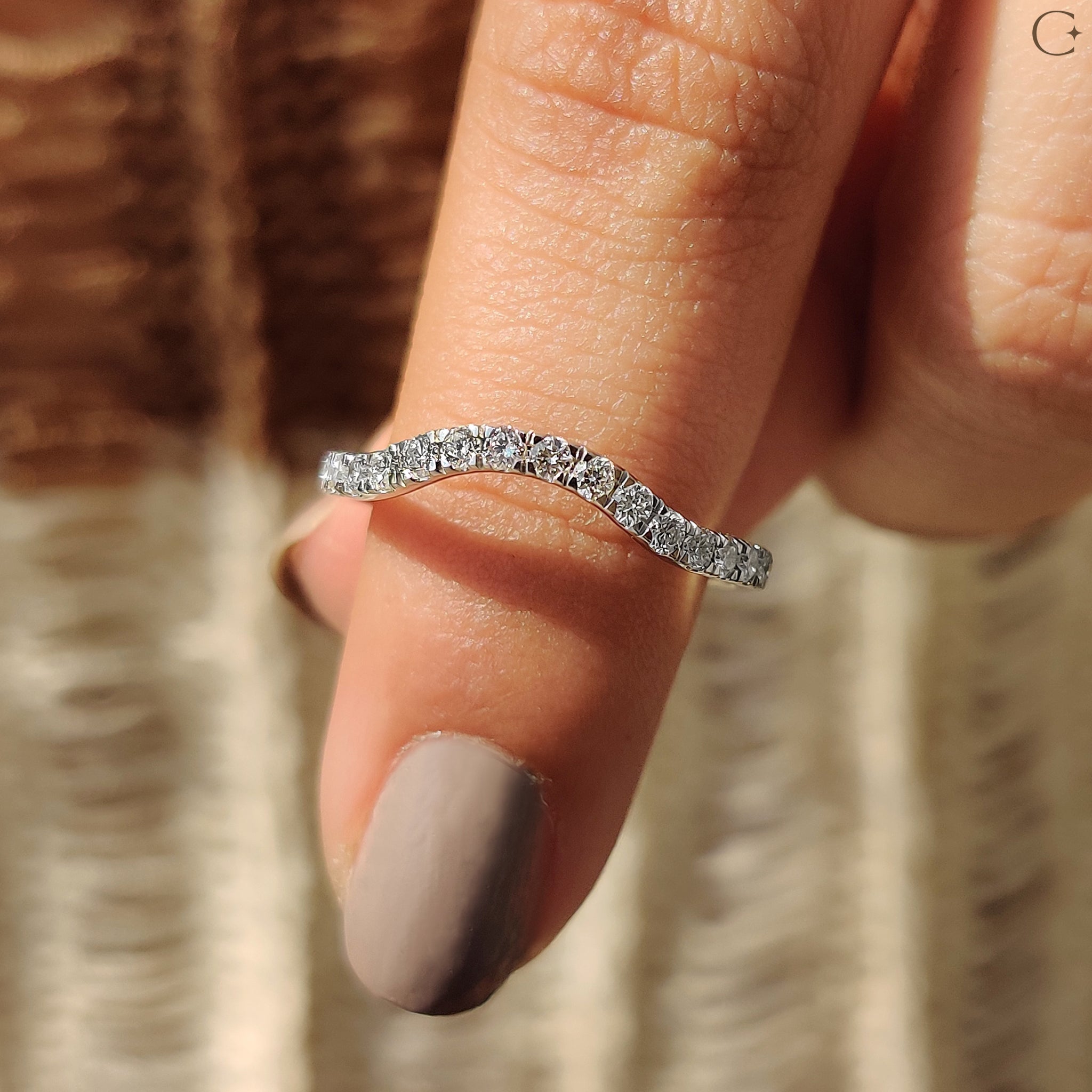 Curved gold wedding band with round cut diamond band.