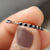 Open gap wedding band with alternating black and white moissanite.