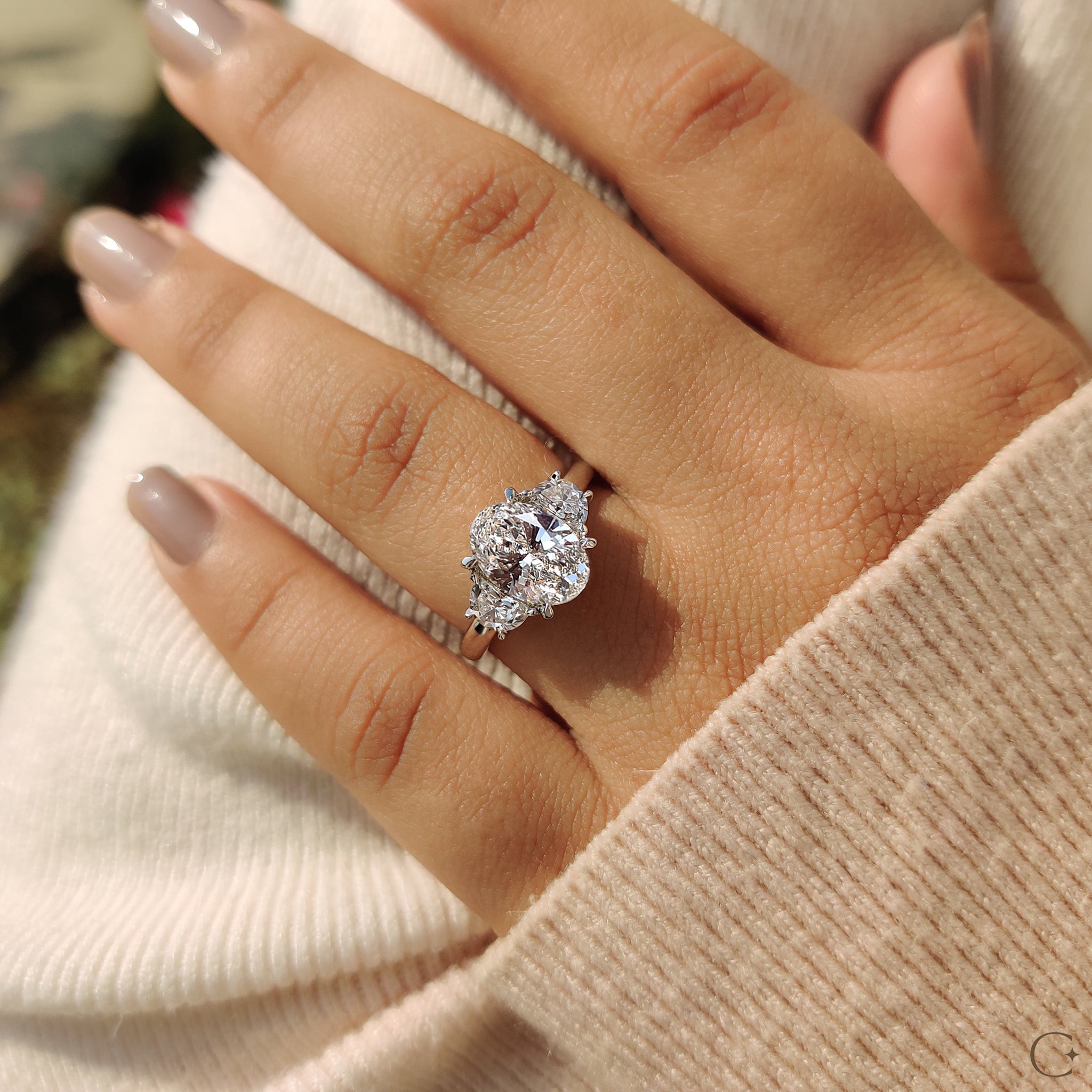 2 half moon side stones accentuating a beautiful oval diamond.
