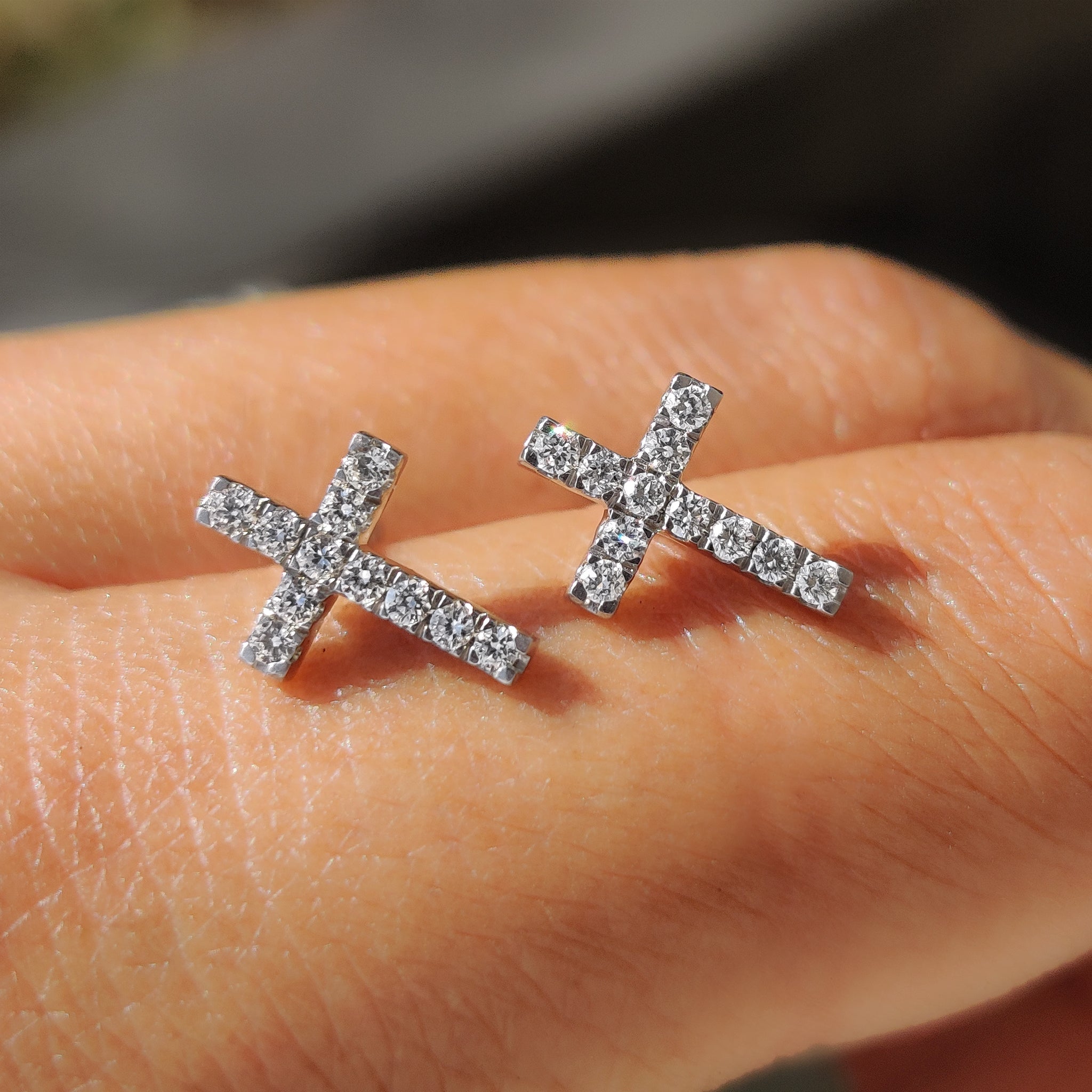Round cut diamond earrings designed as elegant diamond cross earrings.