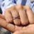 Round cut moissanite wedding band with a micro pave setting and clean criss cross style.