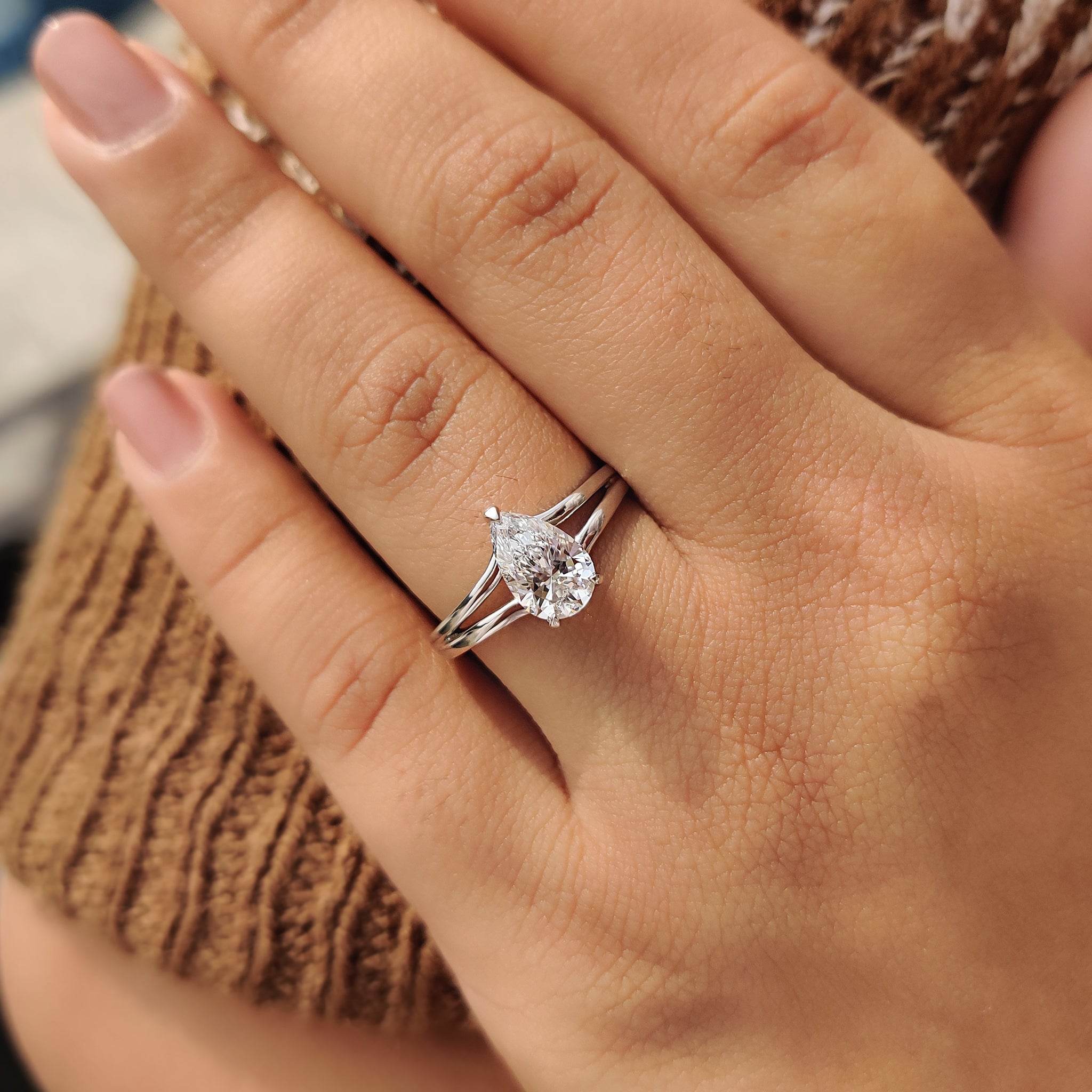White gold engagement ring with a teardrop diamond, blending classic charm and contemporary style.
