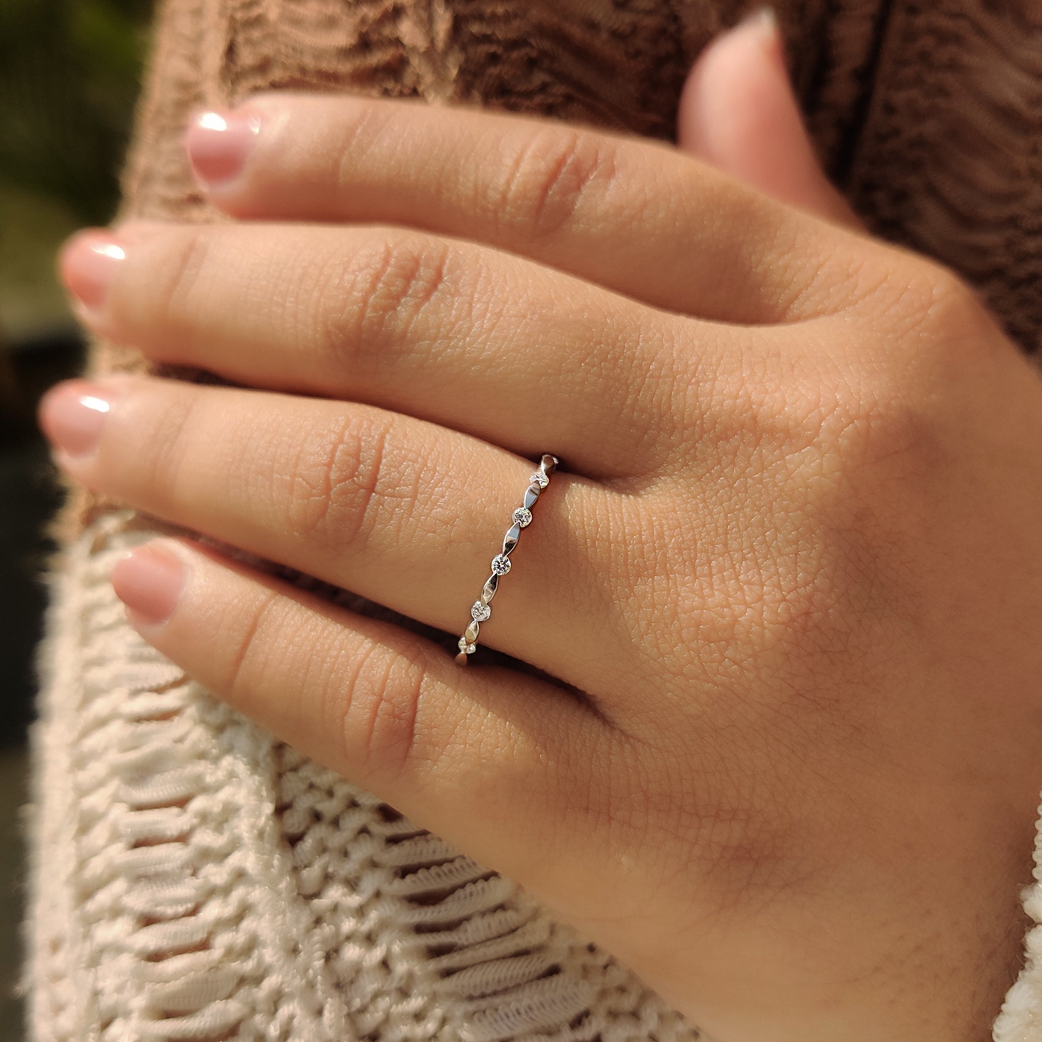 Stackable wedding band in white gold with round cut diamonds and minimalist style.

