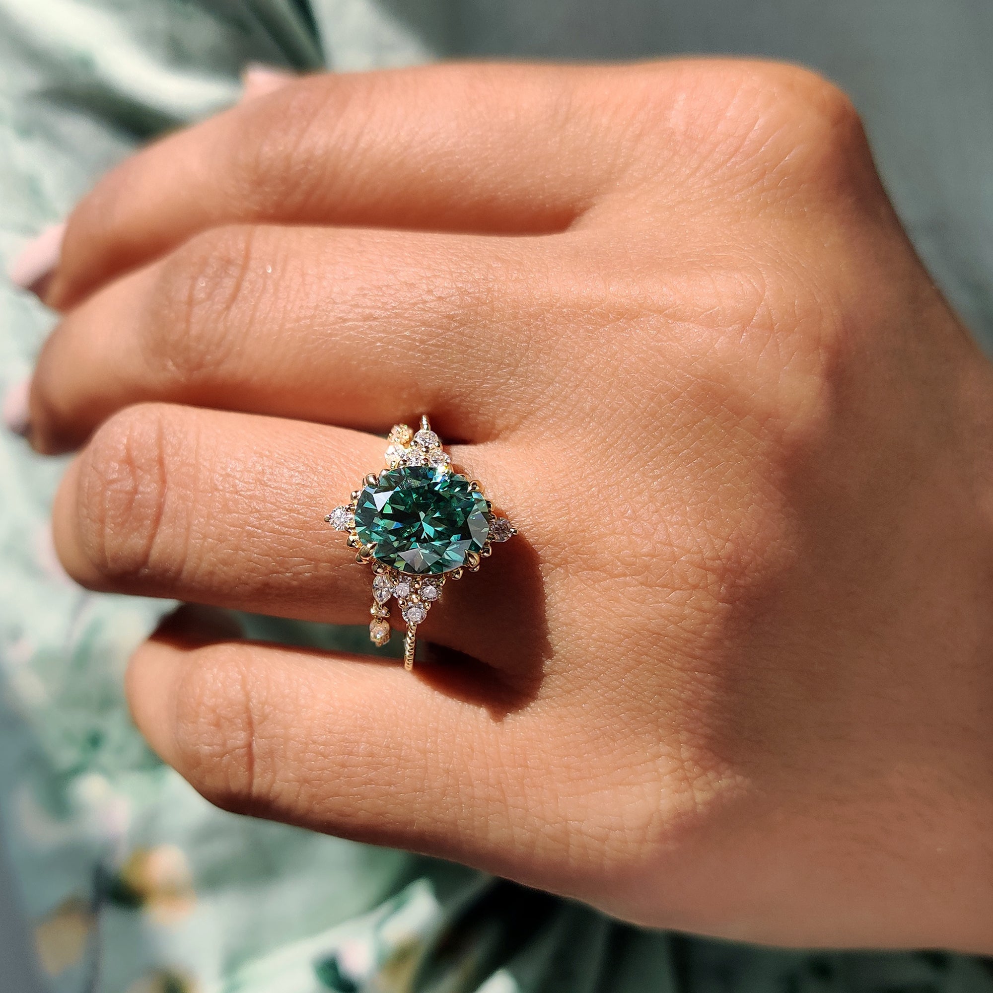 Green stone ring with a muse setting and yellow gold band.
