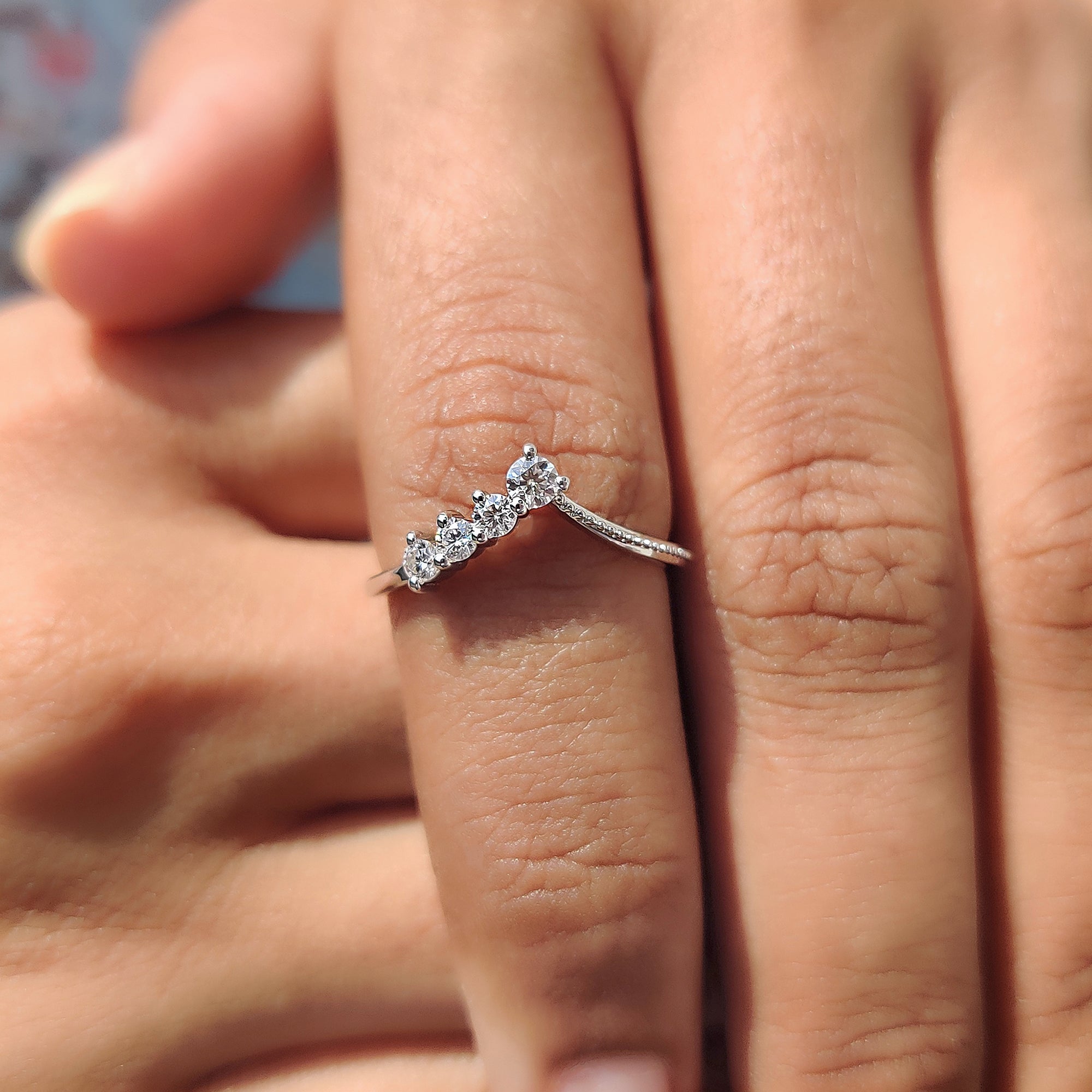 V shaped setting band with round moissanite stones and milgrain detail.