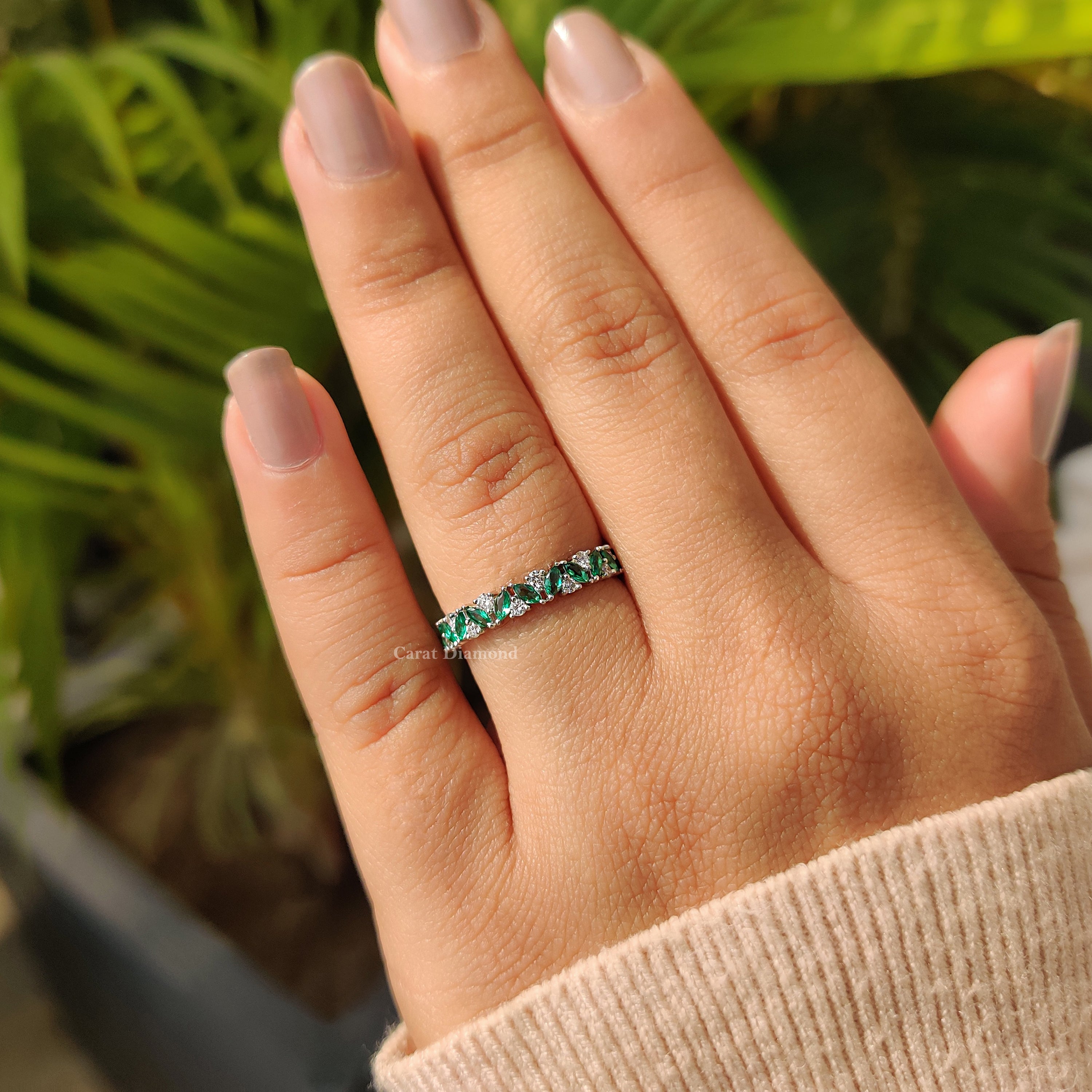 Marquise cut green emerald band with elegant detail.
