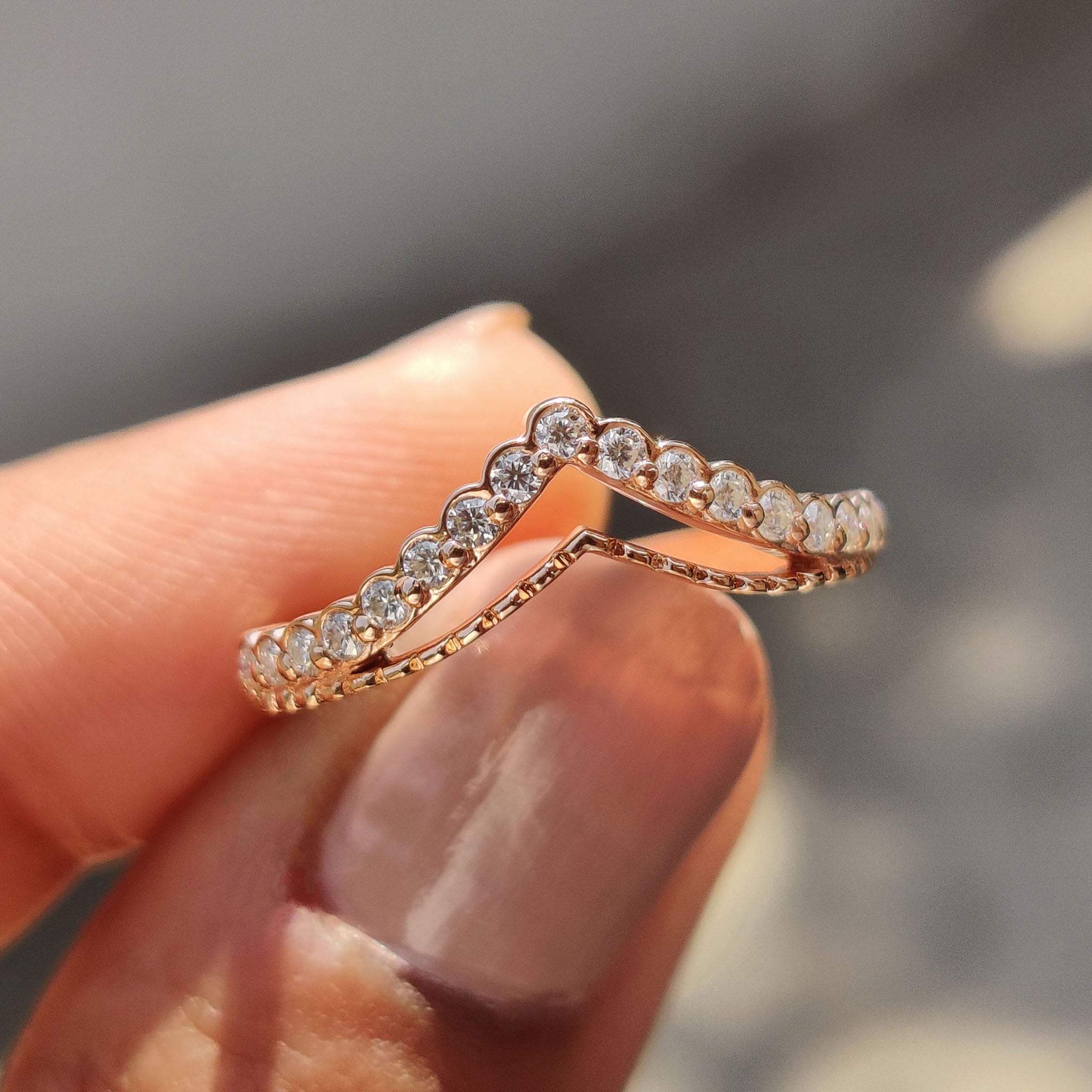 Curvy wedding band in rose gold with round cut Moissanite stones.