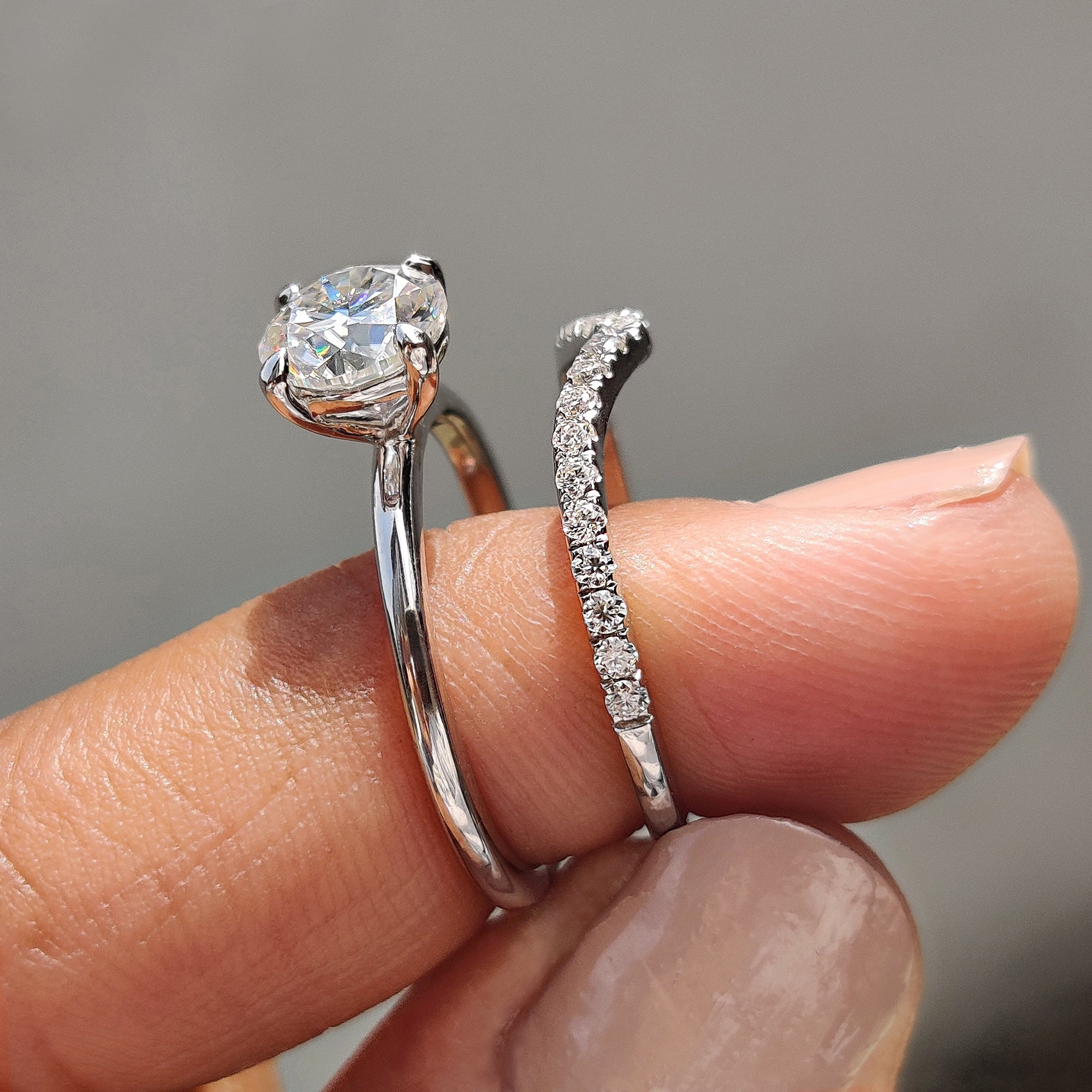Curved wedding band paired with a solitaire engagement ring and moissanite stone.
