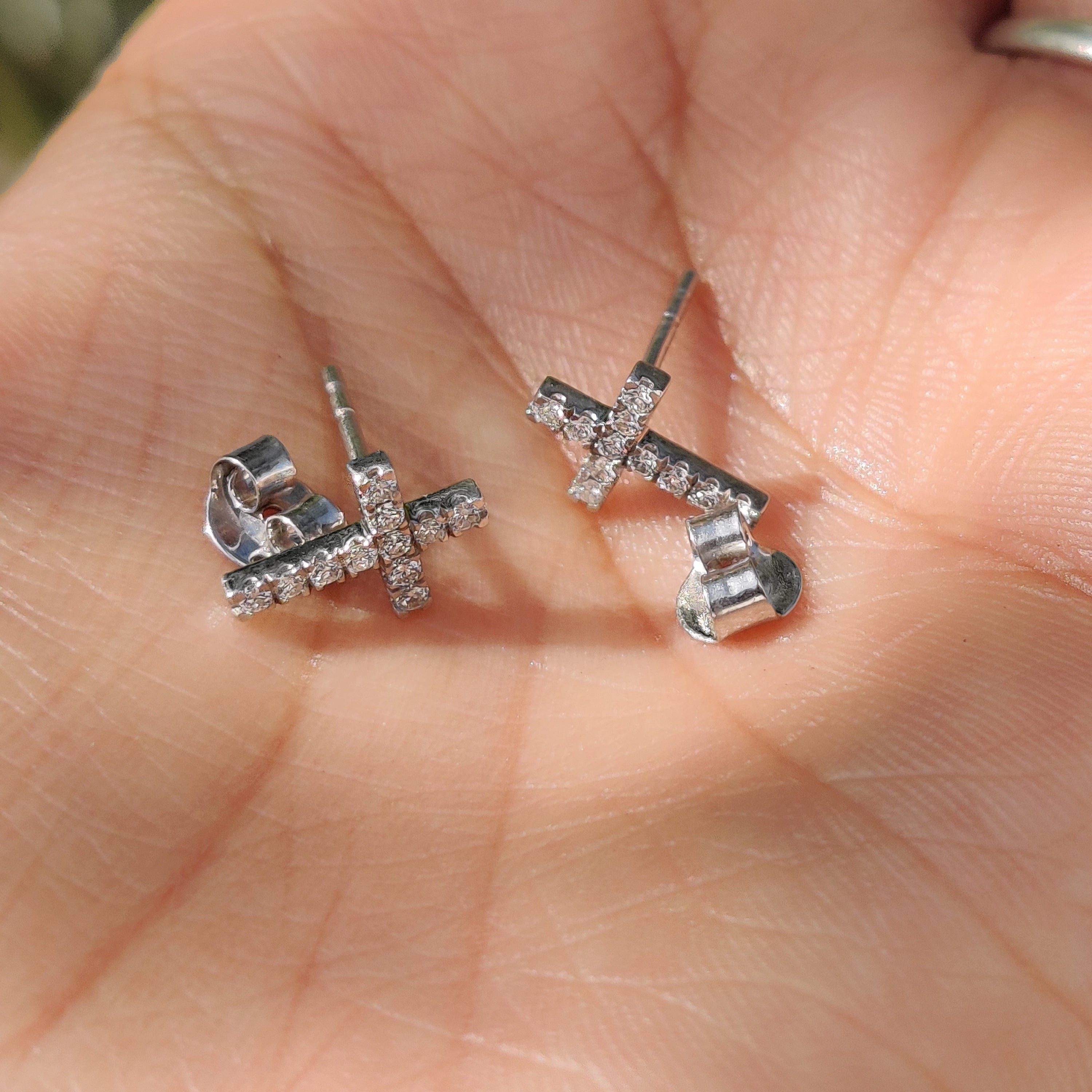 Handmade jewelry showcasing diamond cross earrings in white gold.