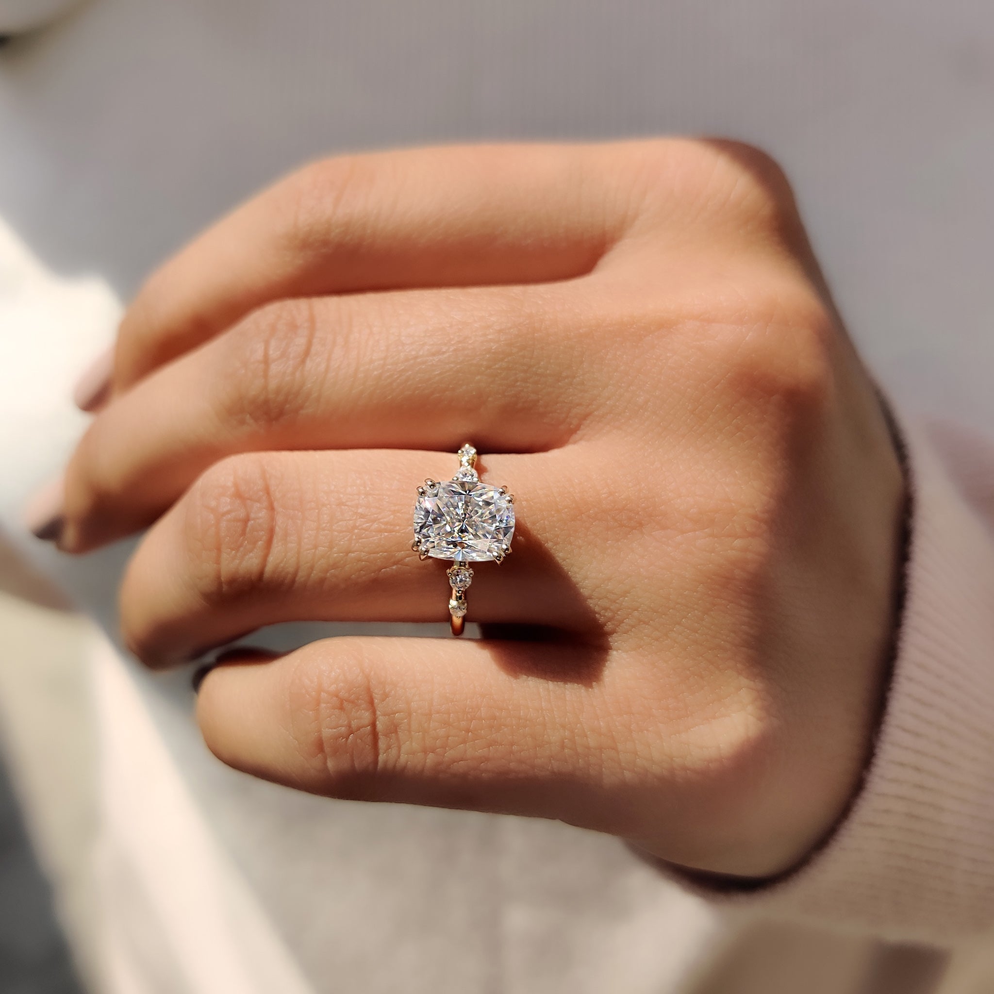 Double prong setting holding cushion and round moissanite.
