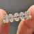 Yellow gold wedding band designed with oval moissanite stones all around.