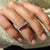 Round diamond eternity band displayed on a neutral ring holder.
