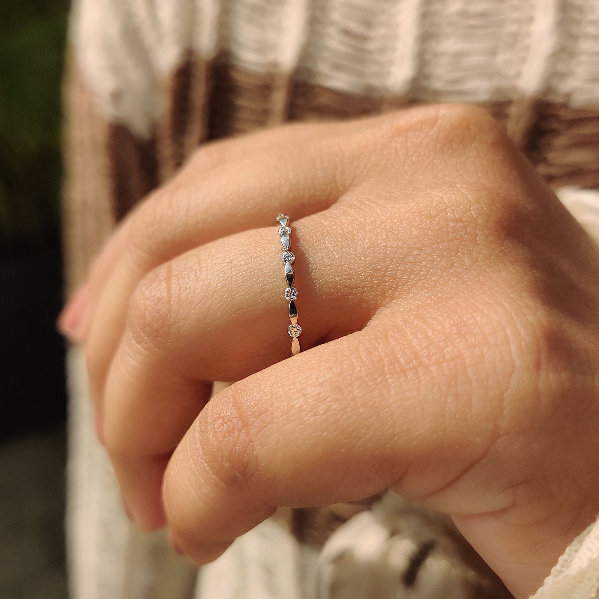 Custom wedding band with distance pave round cut diamonds in white gold.
