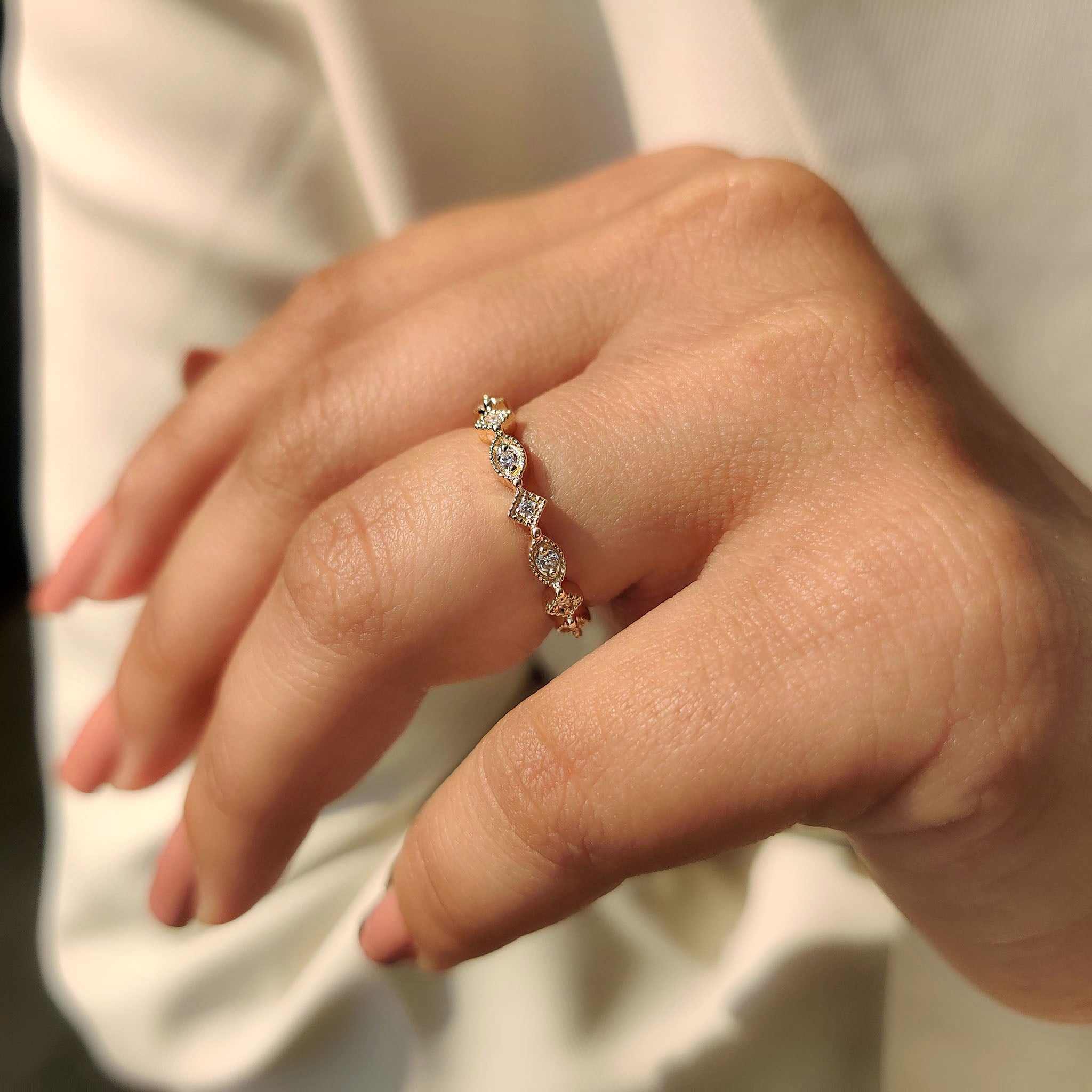 Custom wedding band with milgrain design and round cut diamond in yellow gold.
