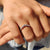 Curvy wedding band designed to fit around solitaires with round cut moissanite stones.
