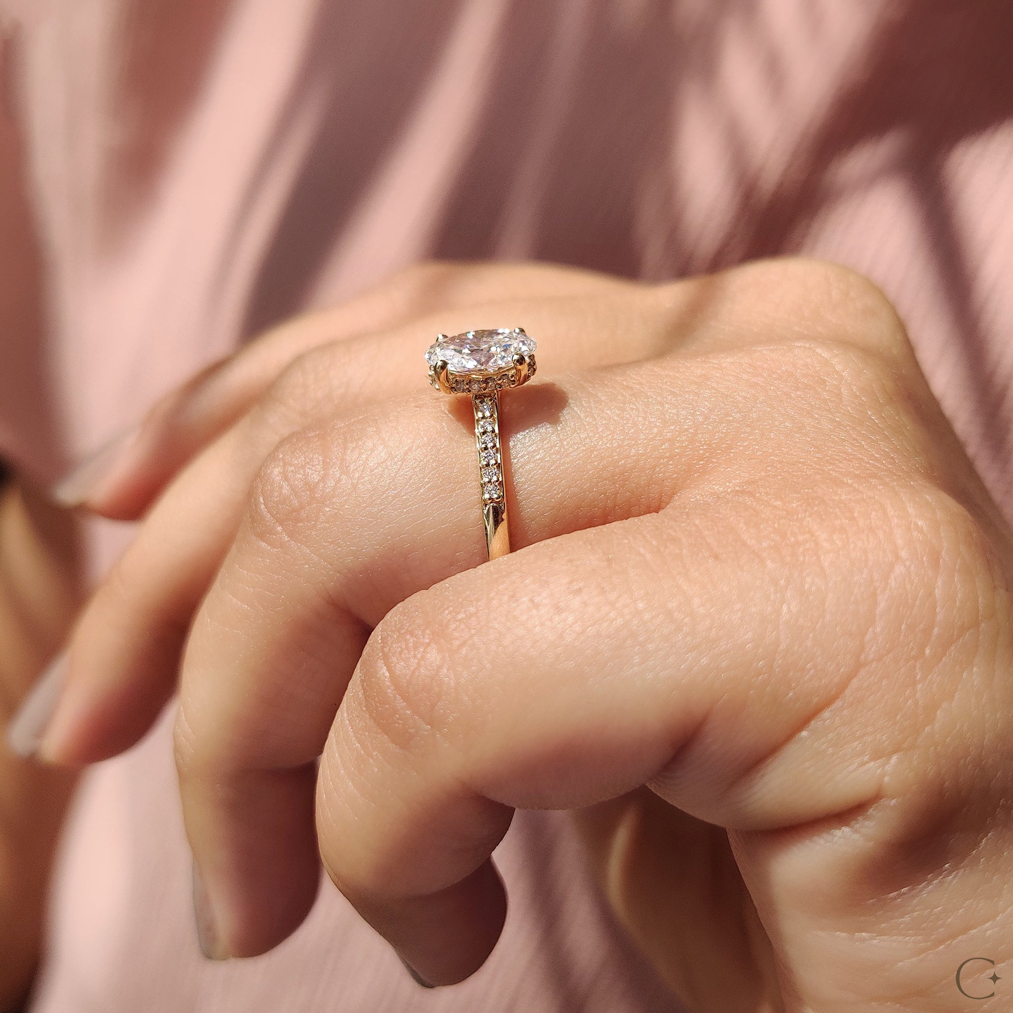 Round cut diamond side stones accenting the central gem.
