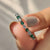 Emerald and diamond wedding band with round cut green emeralds.
