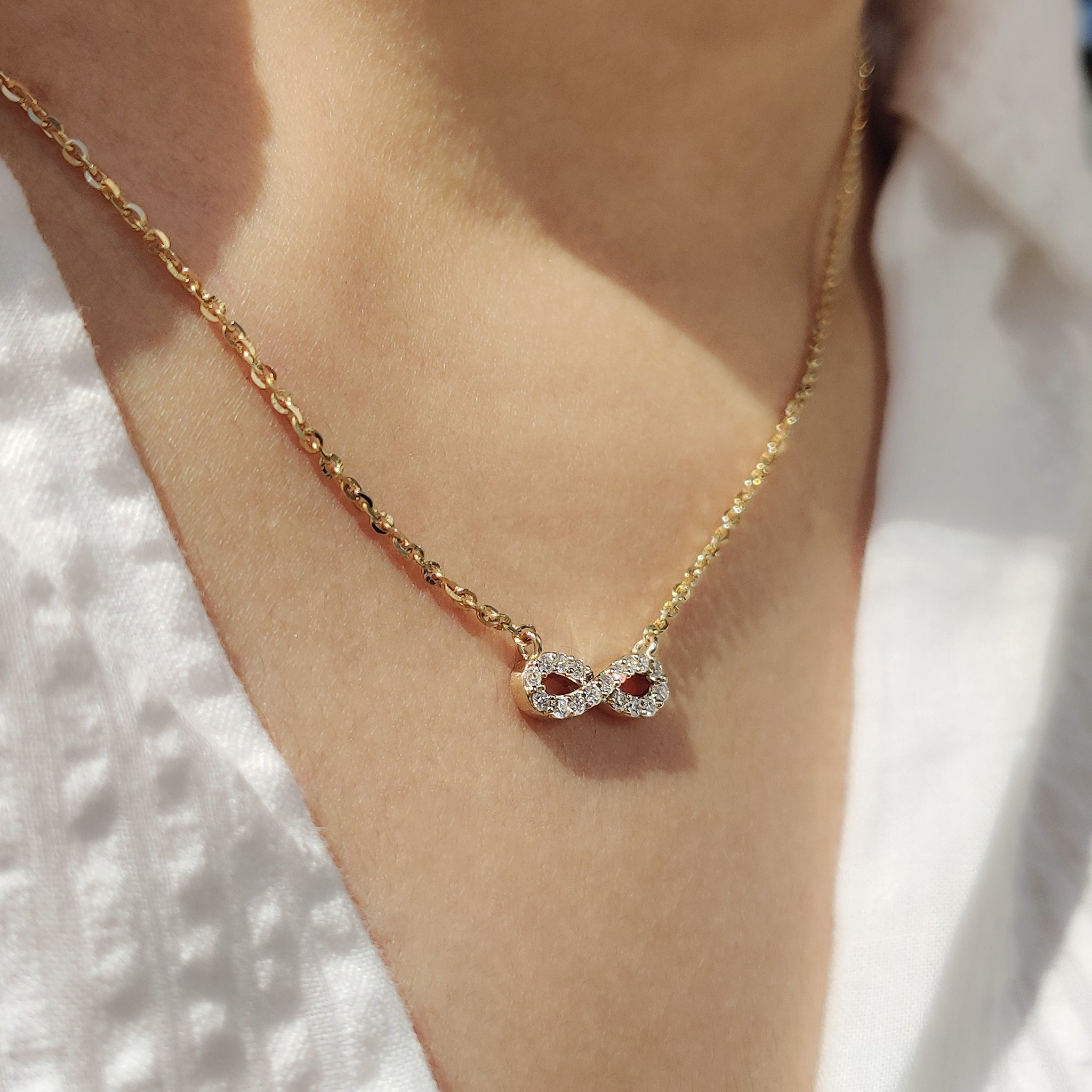 Unique diamond pendant in gold infinity design.