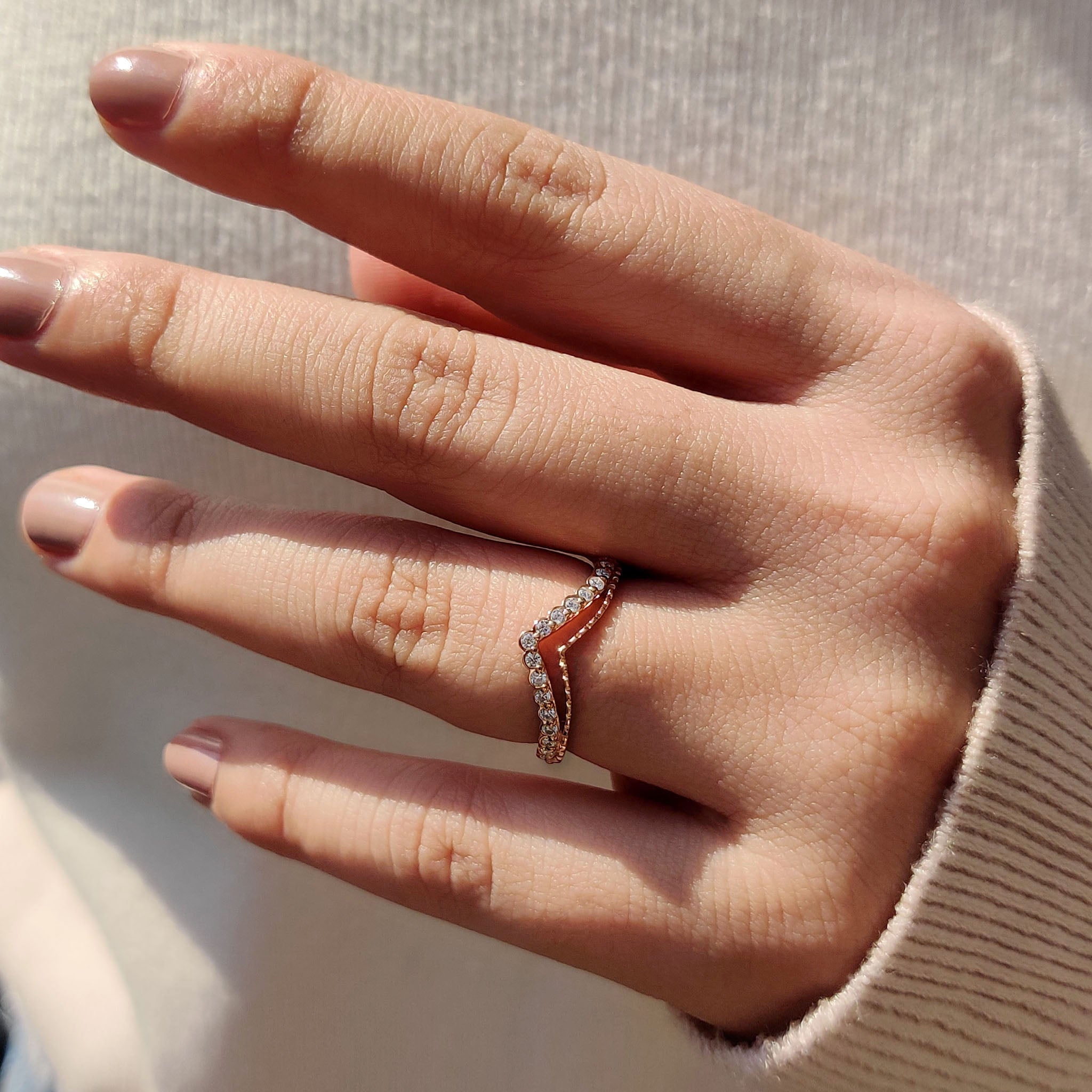 Double chevron wedding band in rose gold with prong setting.