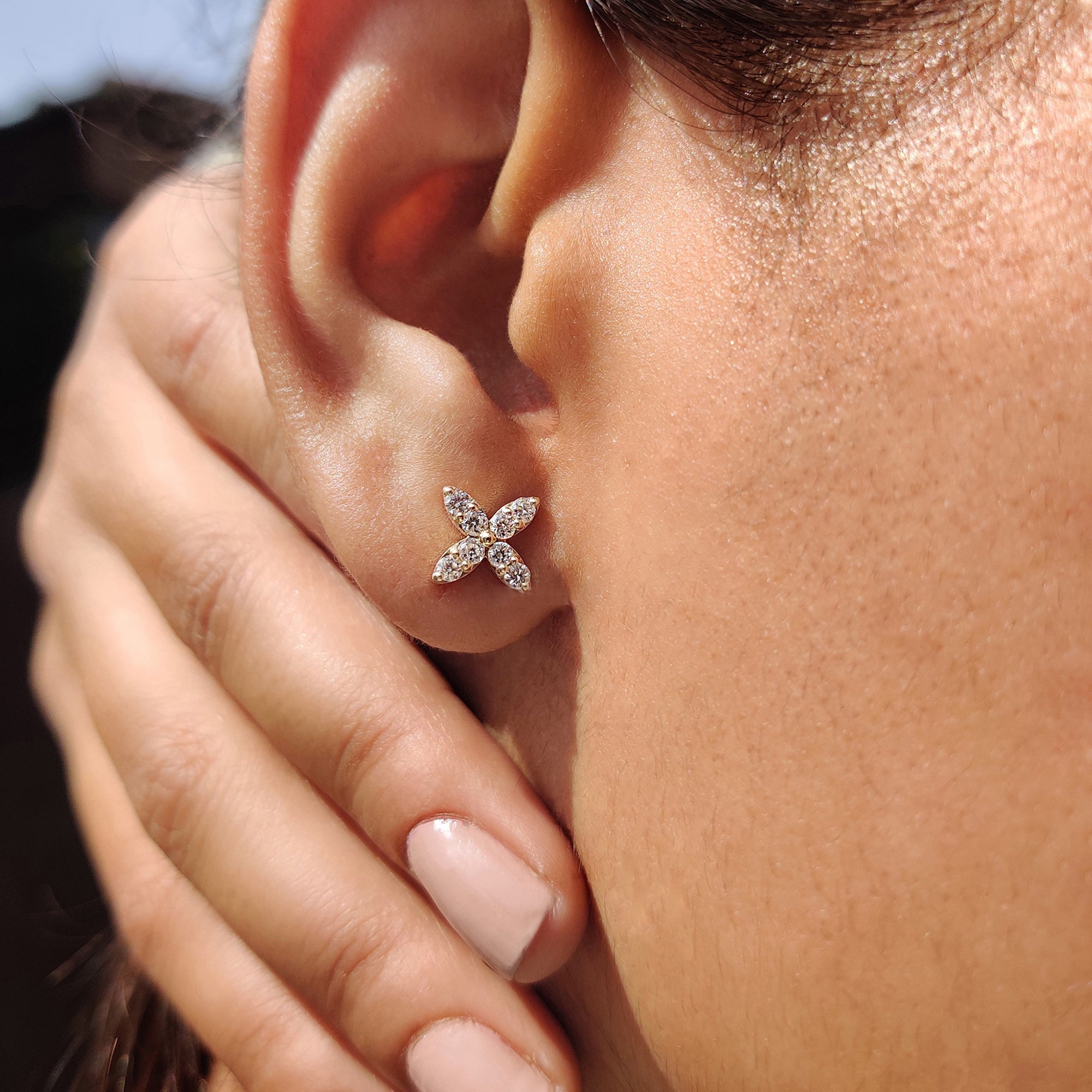 Flower shaped stud earrings with brilliant round diamonds.