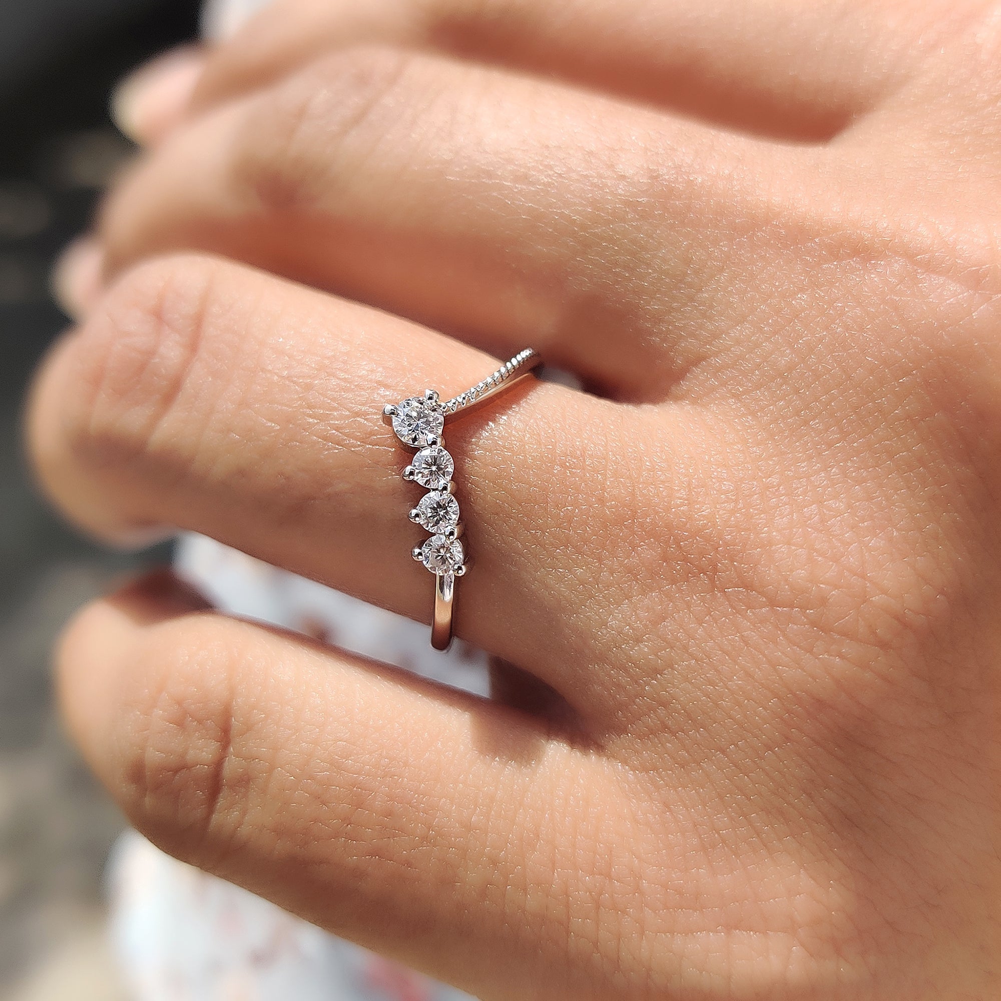 Curved wedding band featuring white gold and round cut stones.