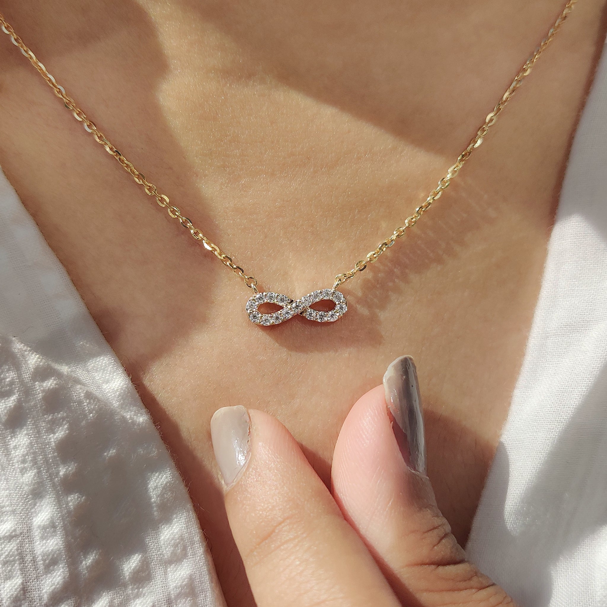 Lab grown diamond pendant in gold infinity style.