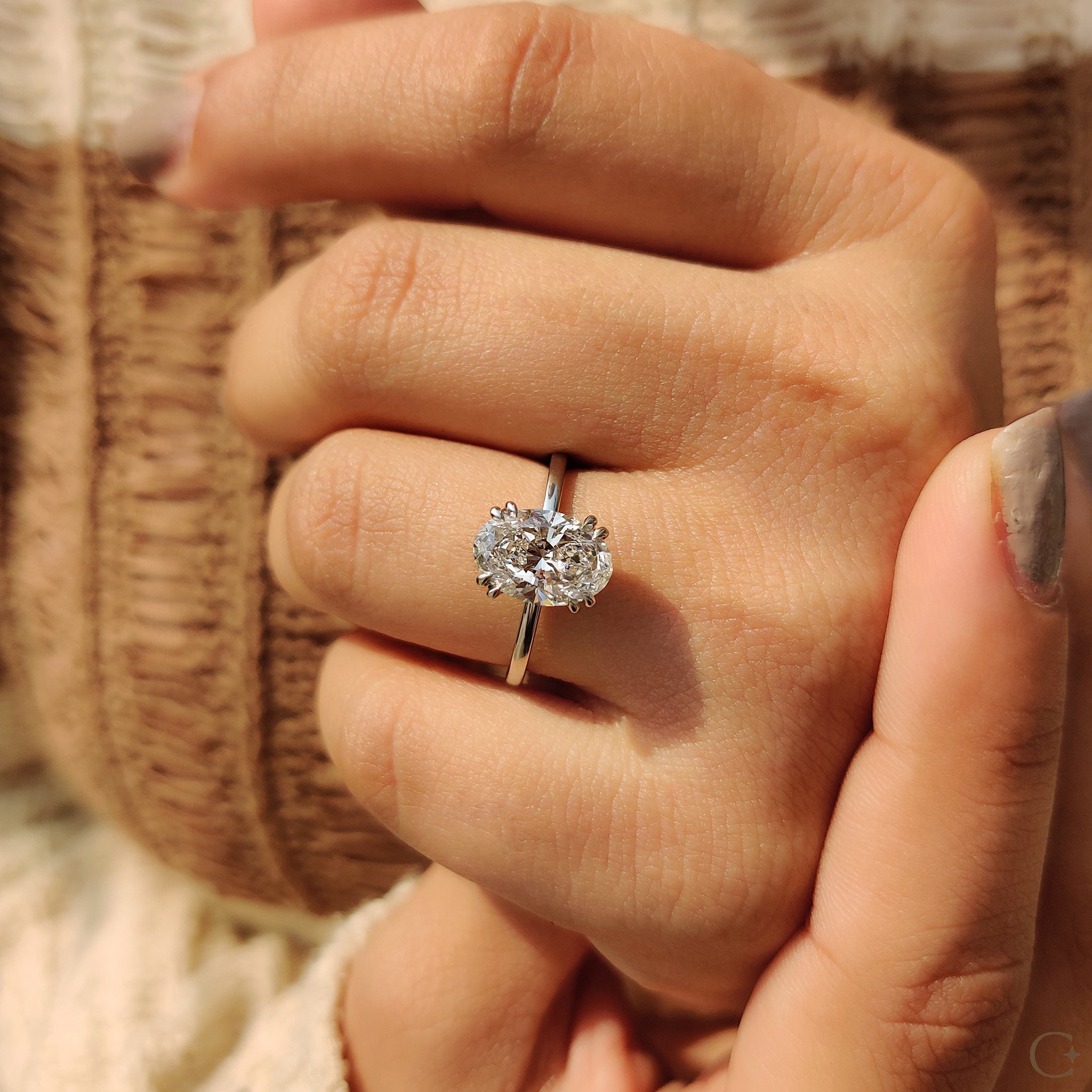 White gold engagement ring with a sparkling oval diamond.

