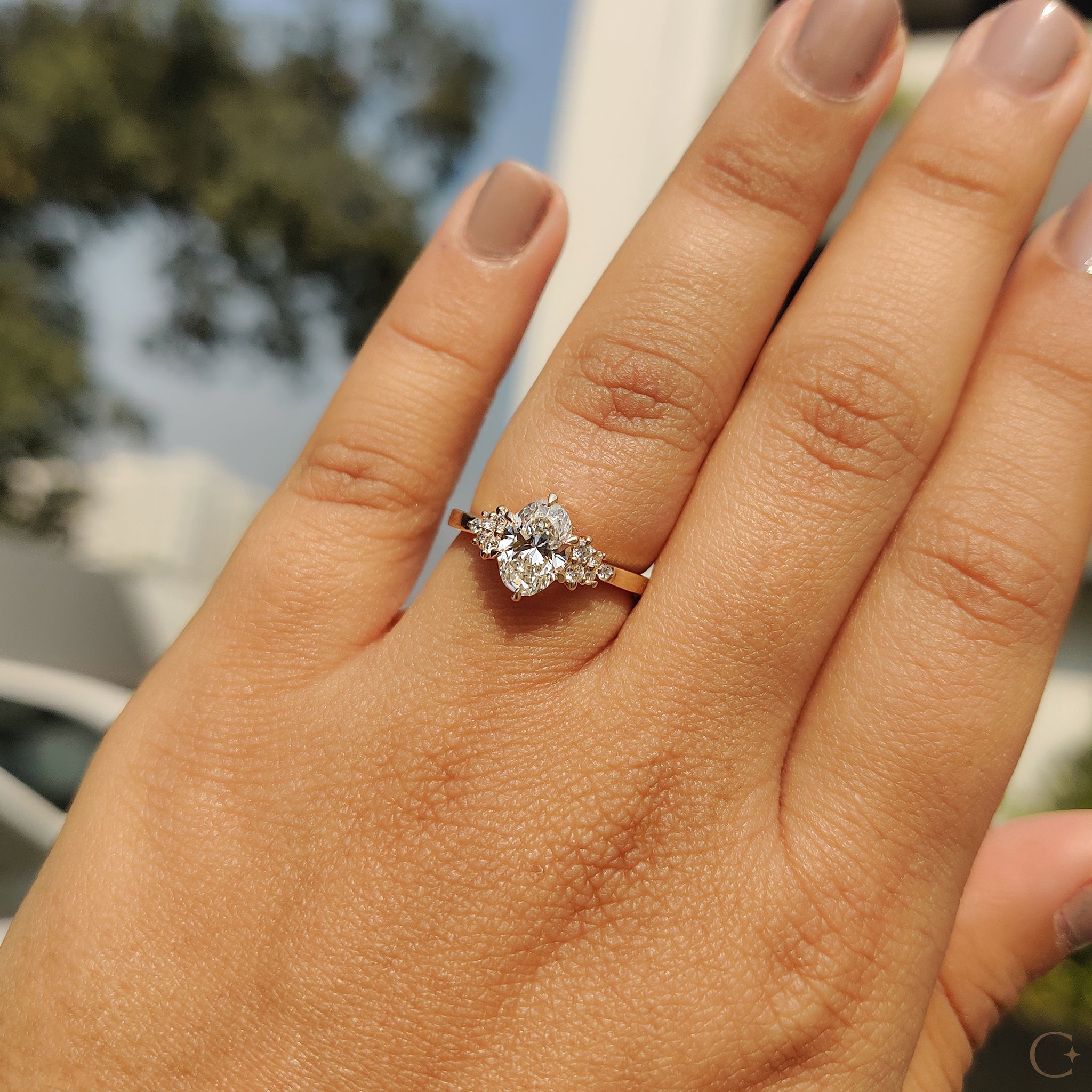 Round side stones enhancing the center diamond.
