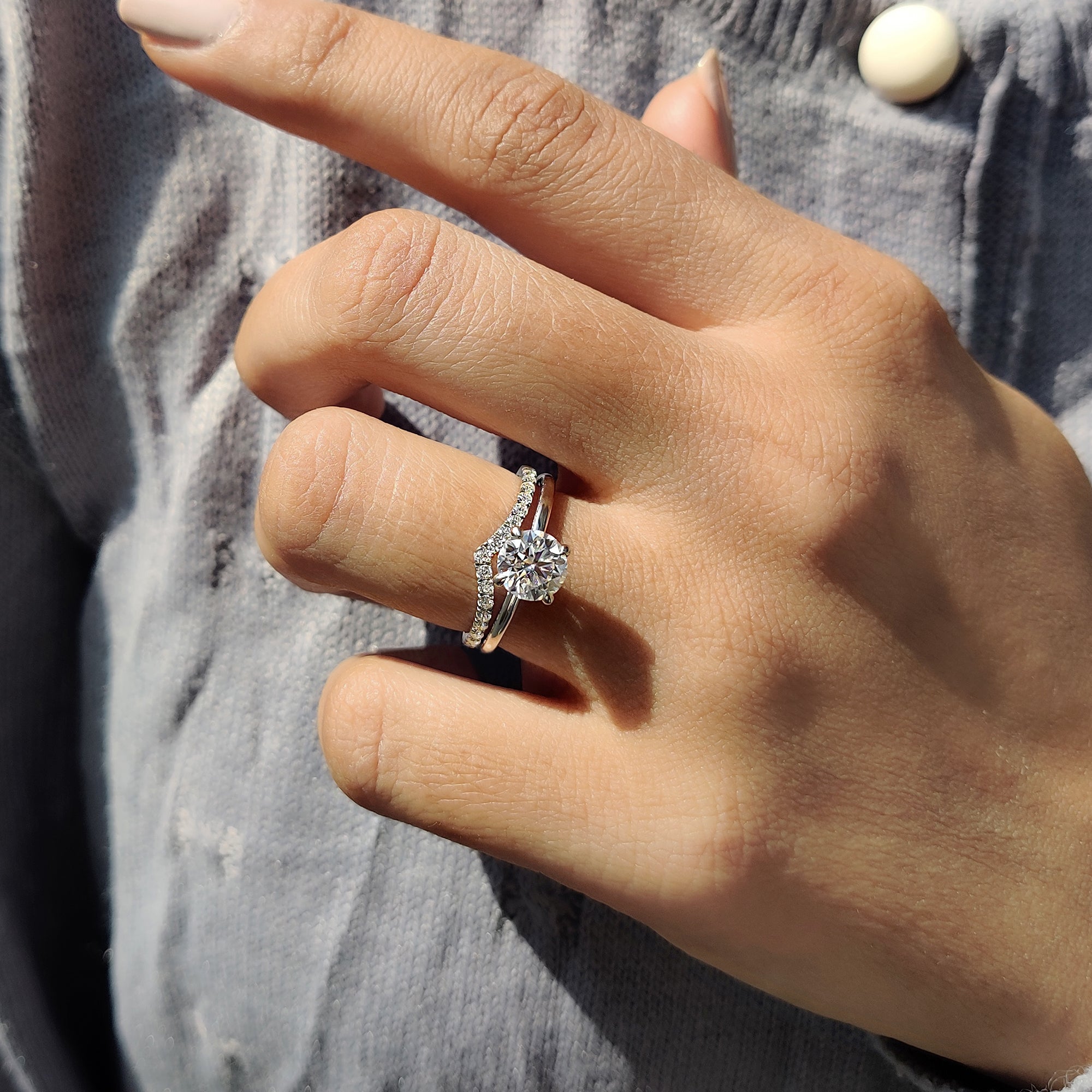 V shaped wedding band stacked with a white gold round cut moissanite ring.
