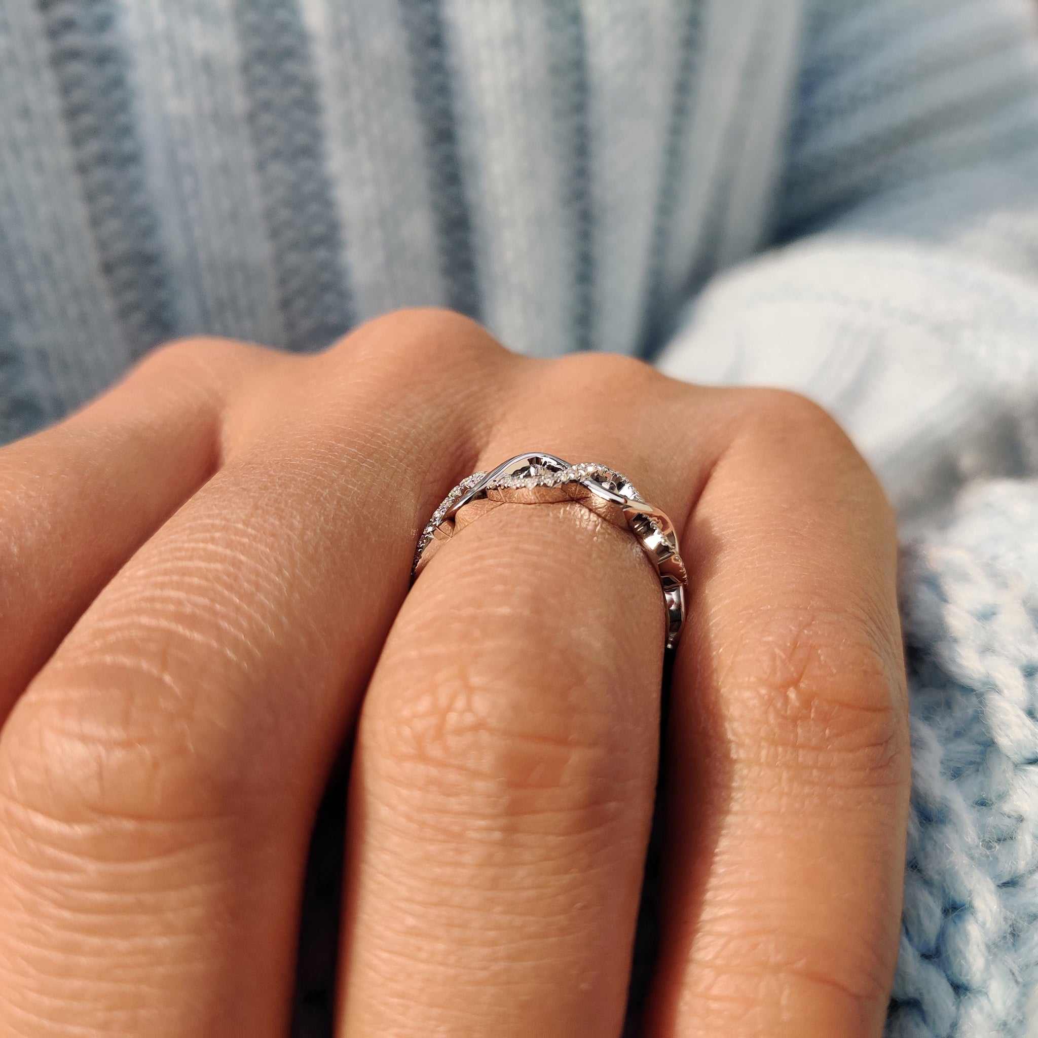 Custom wedding band crafted with a twist design and secure moissanite settings.