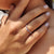 Prong setting band with curved style and round moissanite stones.