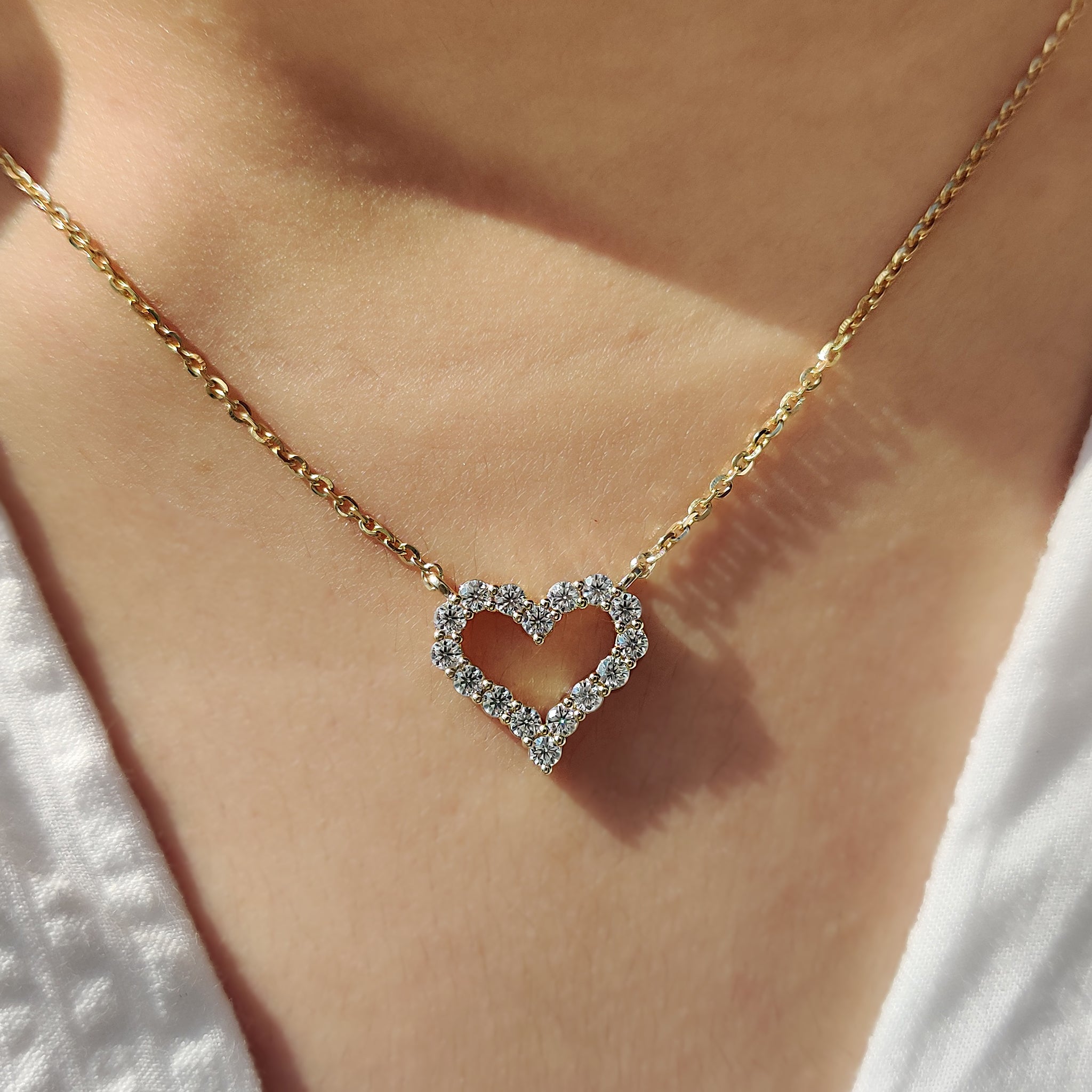 Gold heart pendant with subtle diamond detailing.

