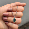 Delicate Solitaire Pendant designed with Lozenge Step Cut cyan blue Moissanite.
