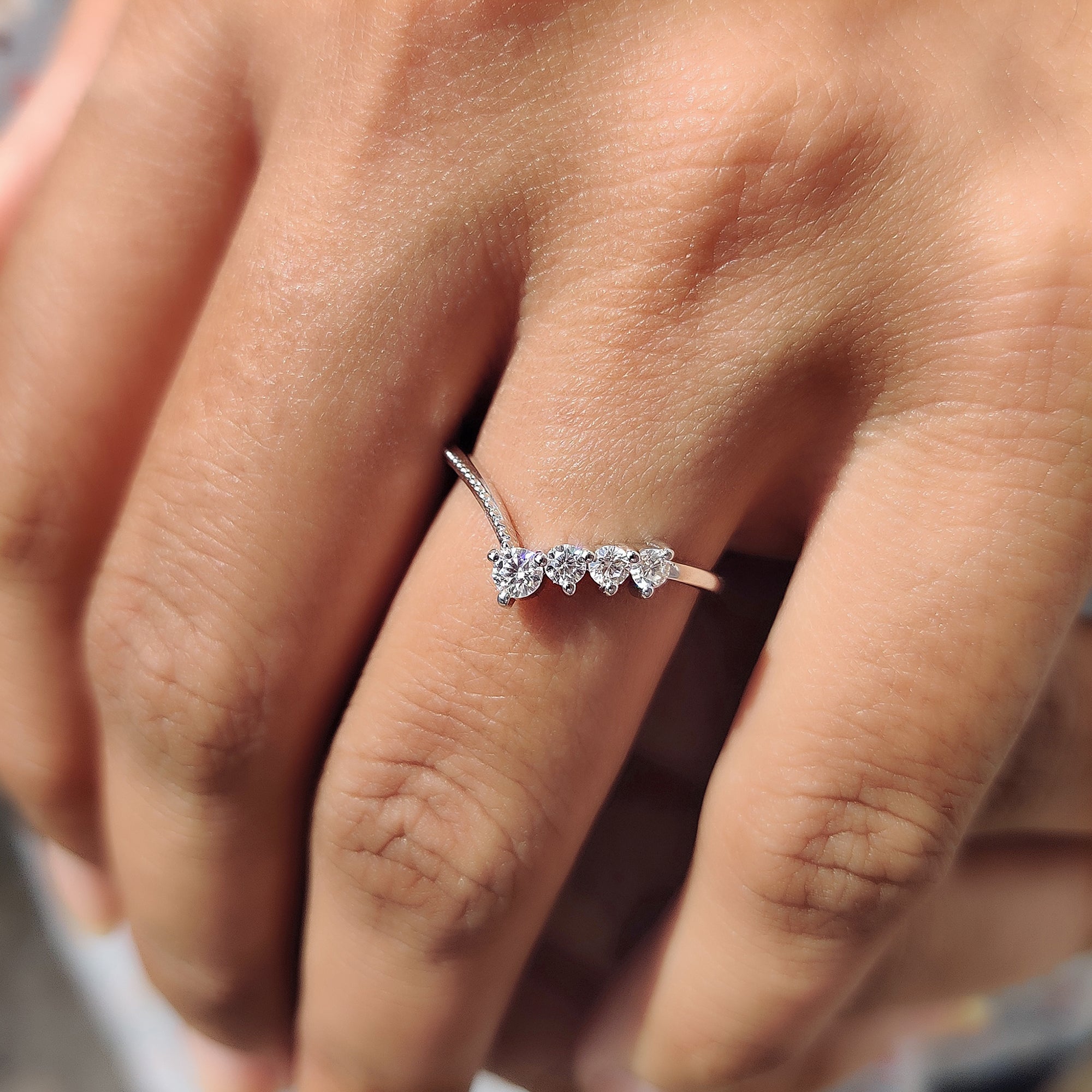 Unique milgrain setting in a v-shaped round cut moissanite band.