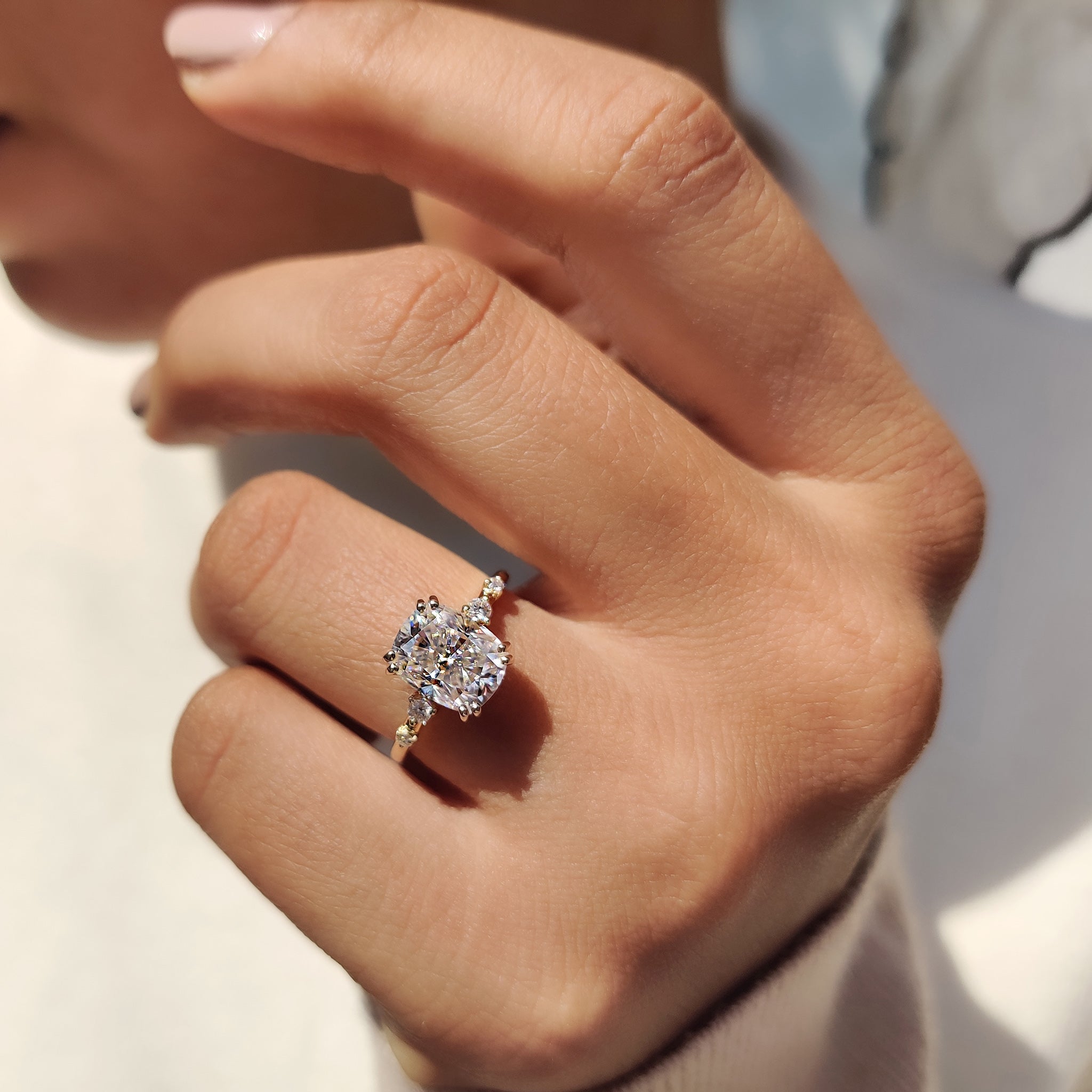 Handmade jewelry featuring cushion and round moissanite.
