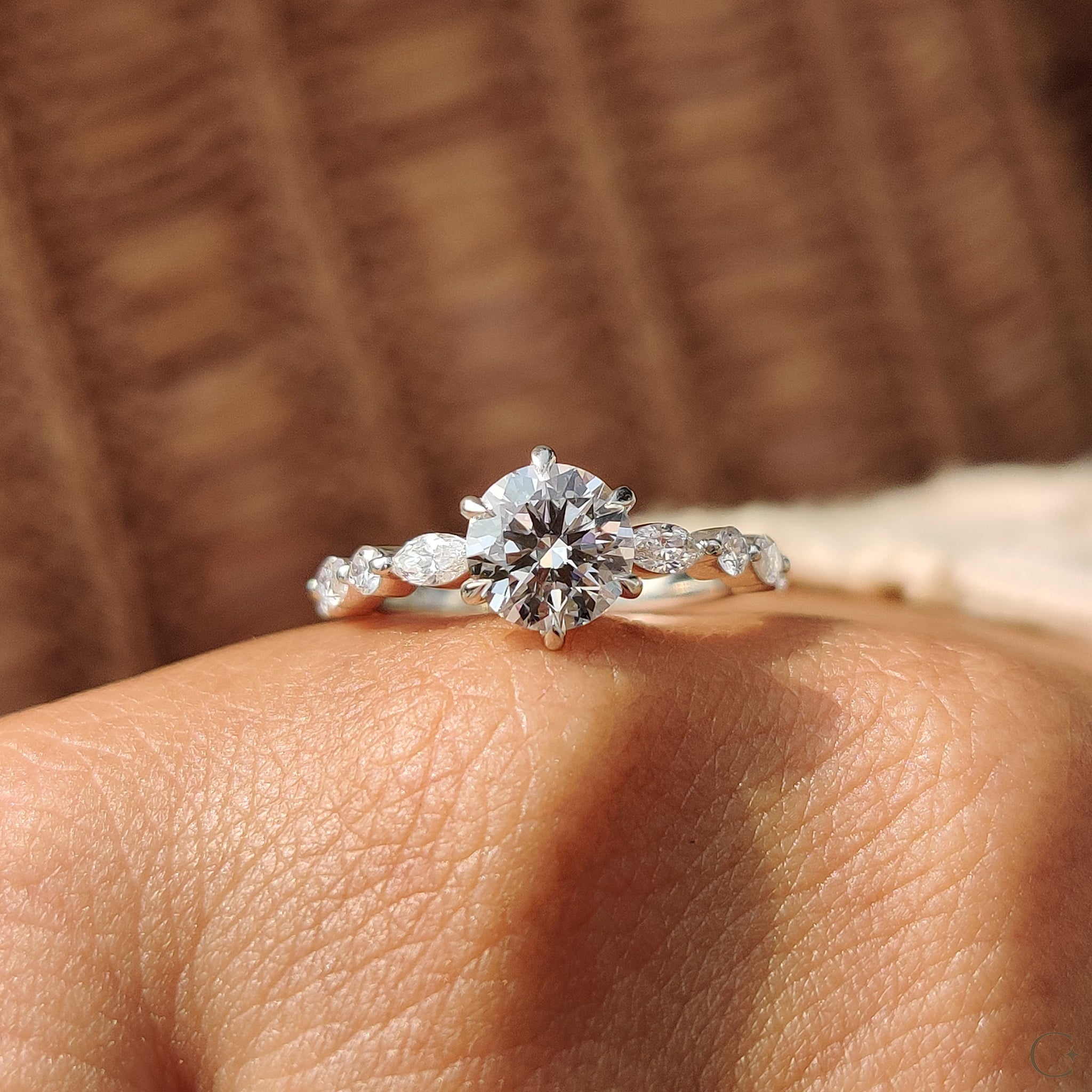 Round and marquise side stones enhancing the engagement ring.
