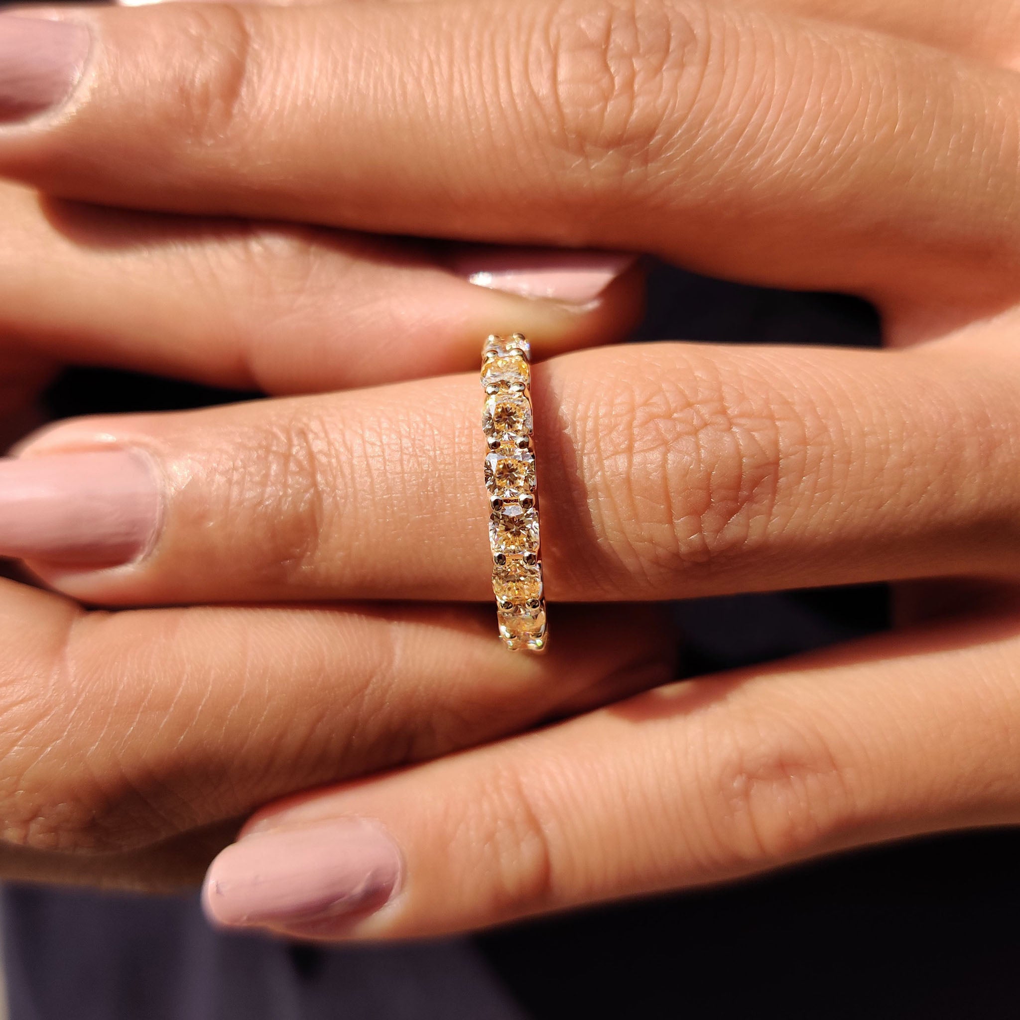 Light yellow moissanite wedding band designed with cushion cut stones and secure prongs.
