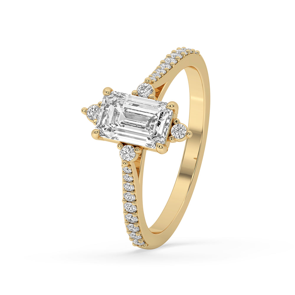 Emerald and diamond ring with 4 claw setting and tapered pave set band, perfect as a unique engagement ring.