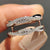Ring enhancer wedding band designed to wrap around solitaire rings for added shape and coverage.