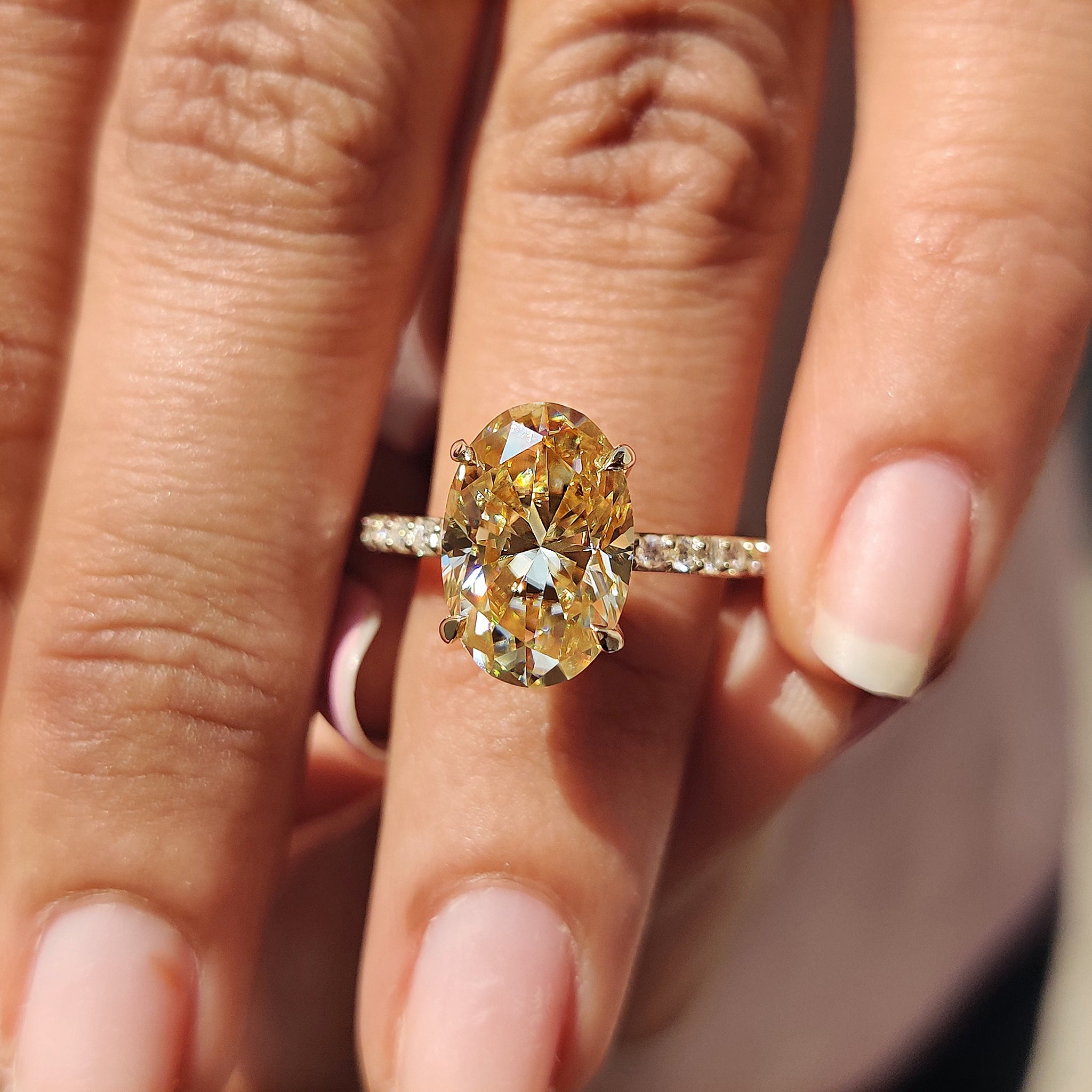 Custom engagement ring with oval Moissanite and a pave setting band for added sparkle.