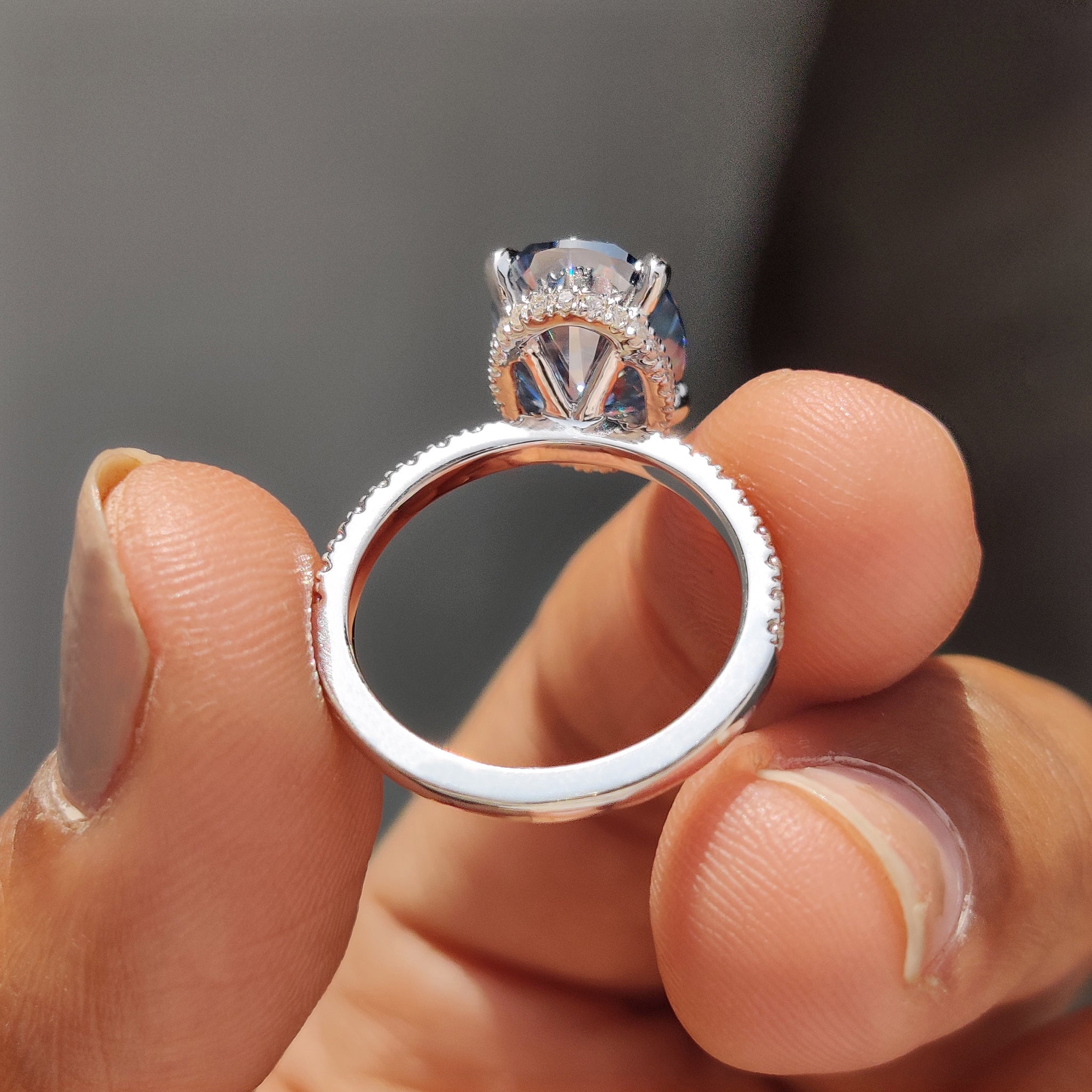 Best engagement ring with a round cut hidden halo setting and oval Moissanite in white gold.
