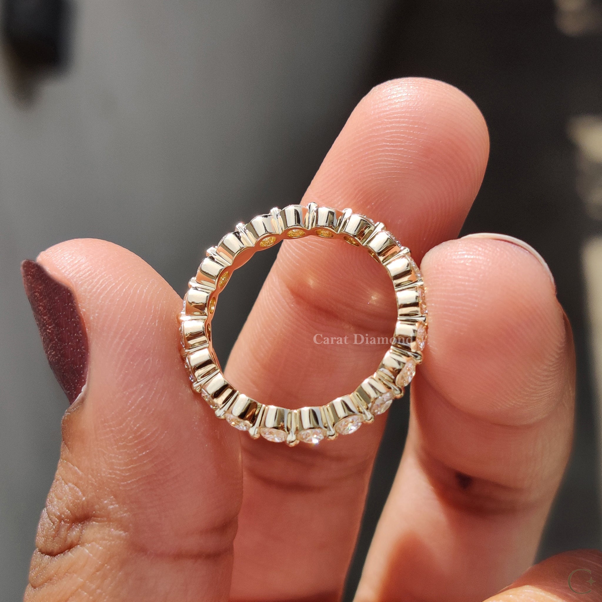 Yellow gold wedding band resting on a velvet cushion.