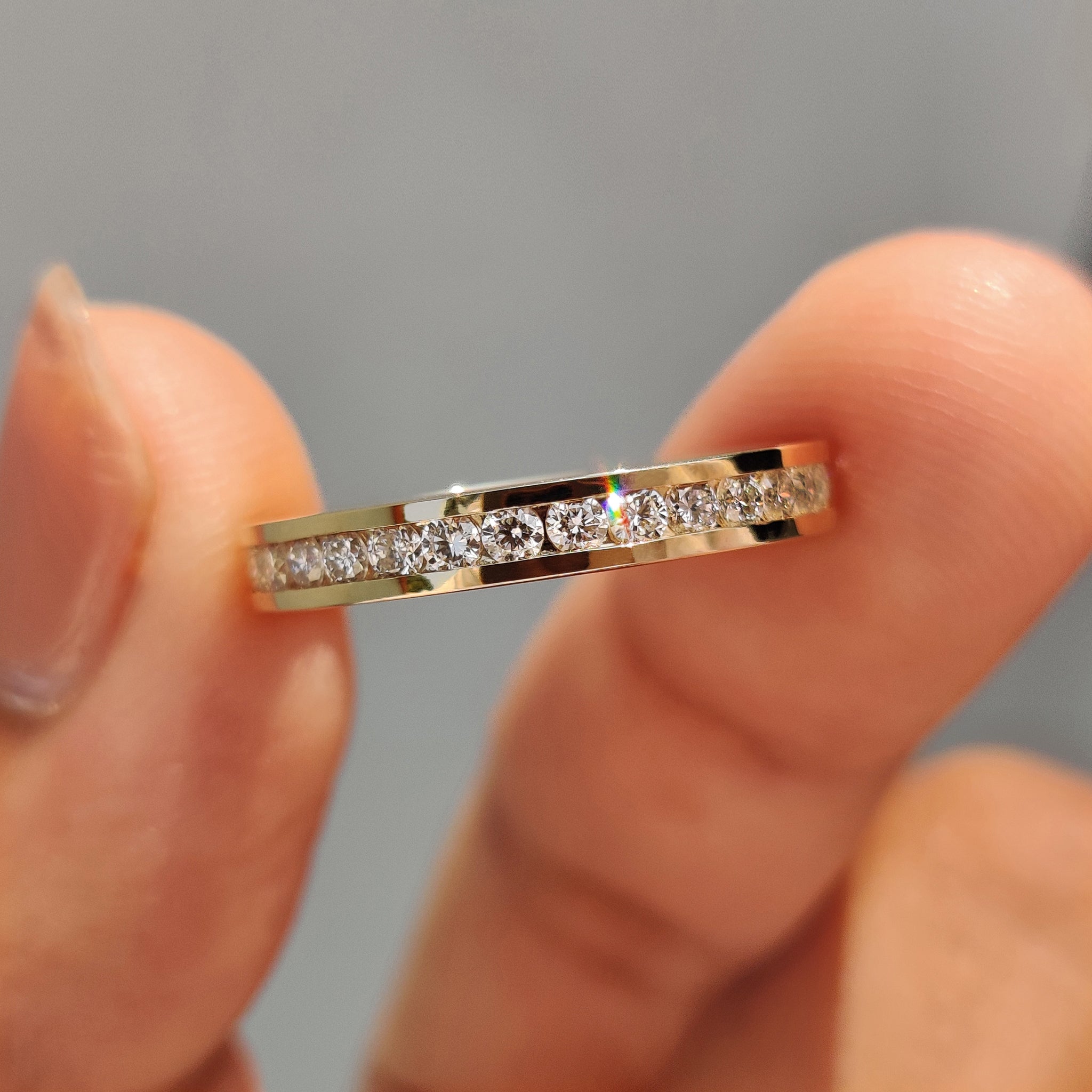 Channel set diamond band featuring a round diamond wedding band.
