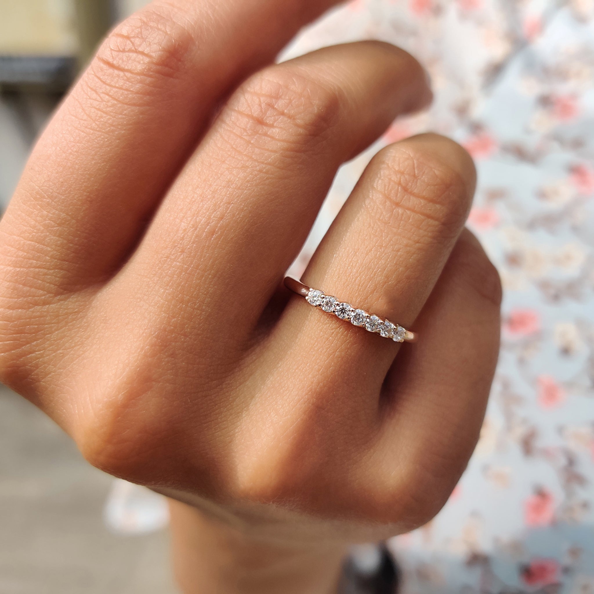 Buy moissanite band in rose gold, featuring round stones and unique design details.