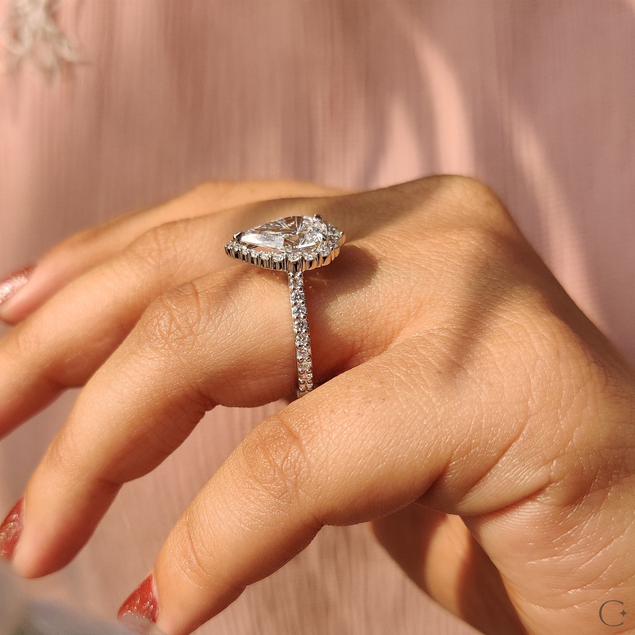 Custom engagement ring featuring a pear cut diamond.
