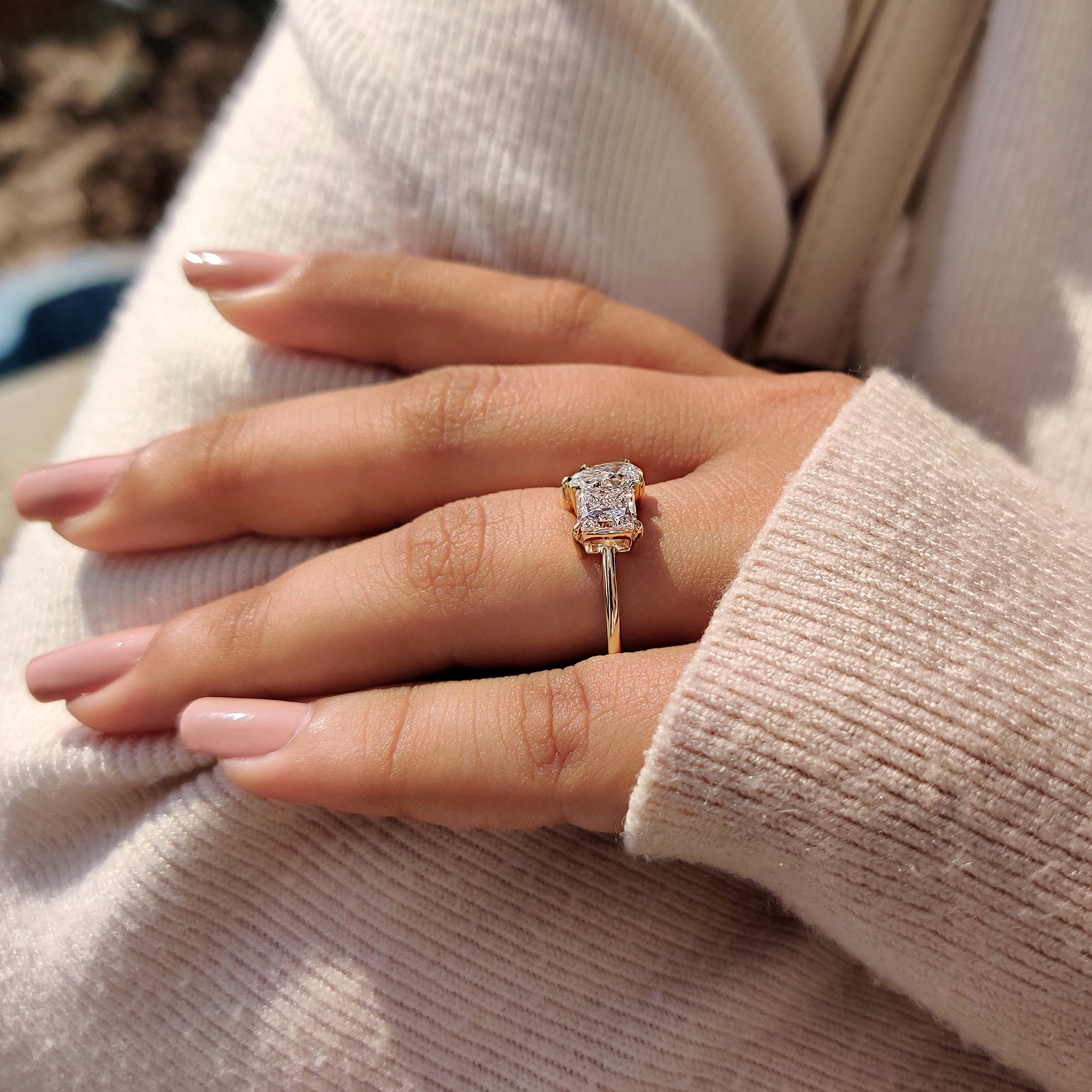 A handmade 2-stone engagement ring showcasing a lab-grown princess cut diamond and a pear cut diamond on a simple yellow gold band.
