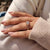 A handmade 2-stone engagement ring showcasing a lab-grown princess cut diamond and a pear cut diamond on a simple yellow gold band.
