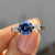 Three stone engagement ring features round cut centre with side accents.
