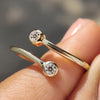 Two stone wedding band featuring round cut moissanite in a modern open gap design.
